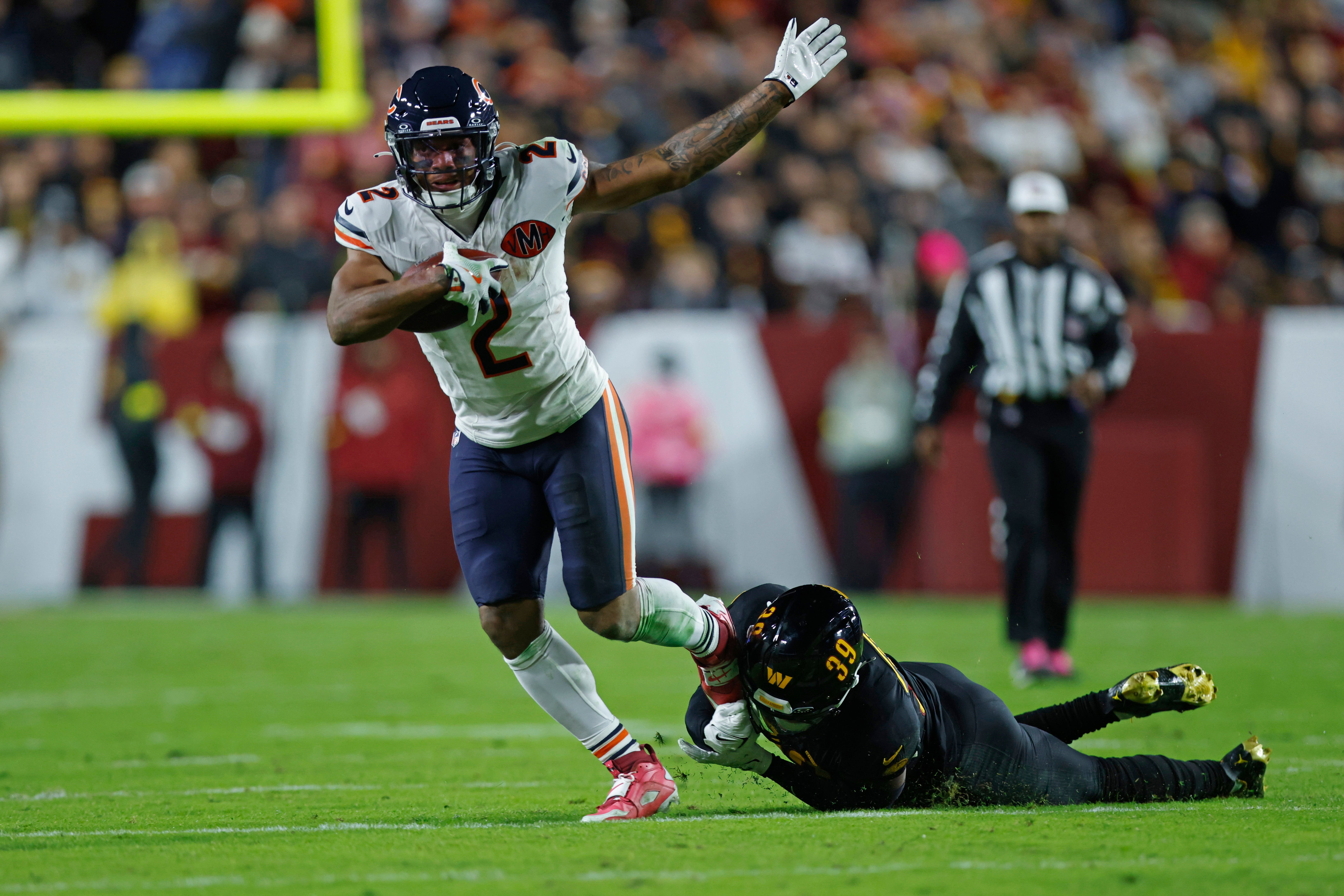 Oct 13, 2025; Landover, Maryland, USA; Chicago Bears wide receiver DJ Moore (2) escapes the tackle of Washington Commanders safety Jeremy Reaves (39) during the first quarter at Northwest Stadium.