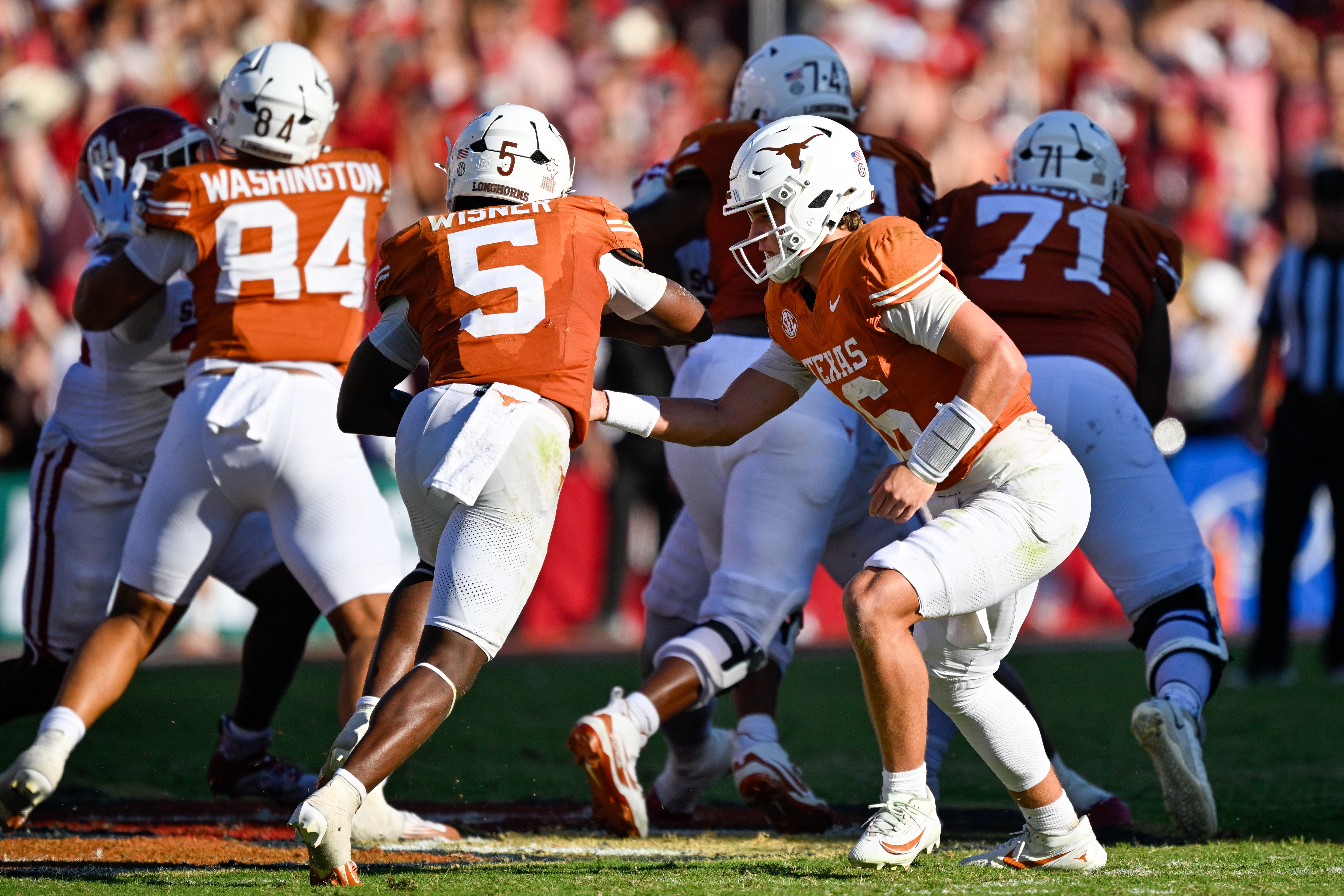Oct 11, 2025; Dallas, Texas, USA; Texas Longhorns quarterback Arch Manning (16) hands off the ball to running back Quintrevion Wisner (5) during the game between the Texas Longhorns and the Oklahoma Sooners at the Cotton Bowl. Mandatory Credit: Jerome Miron-Imagn Images