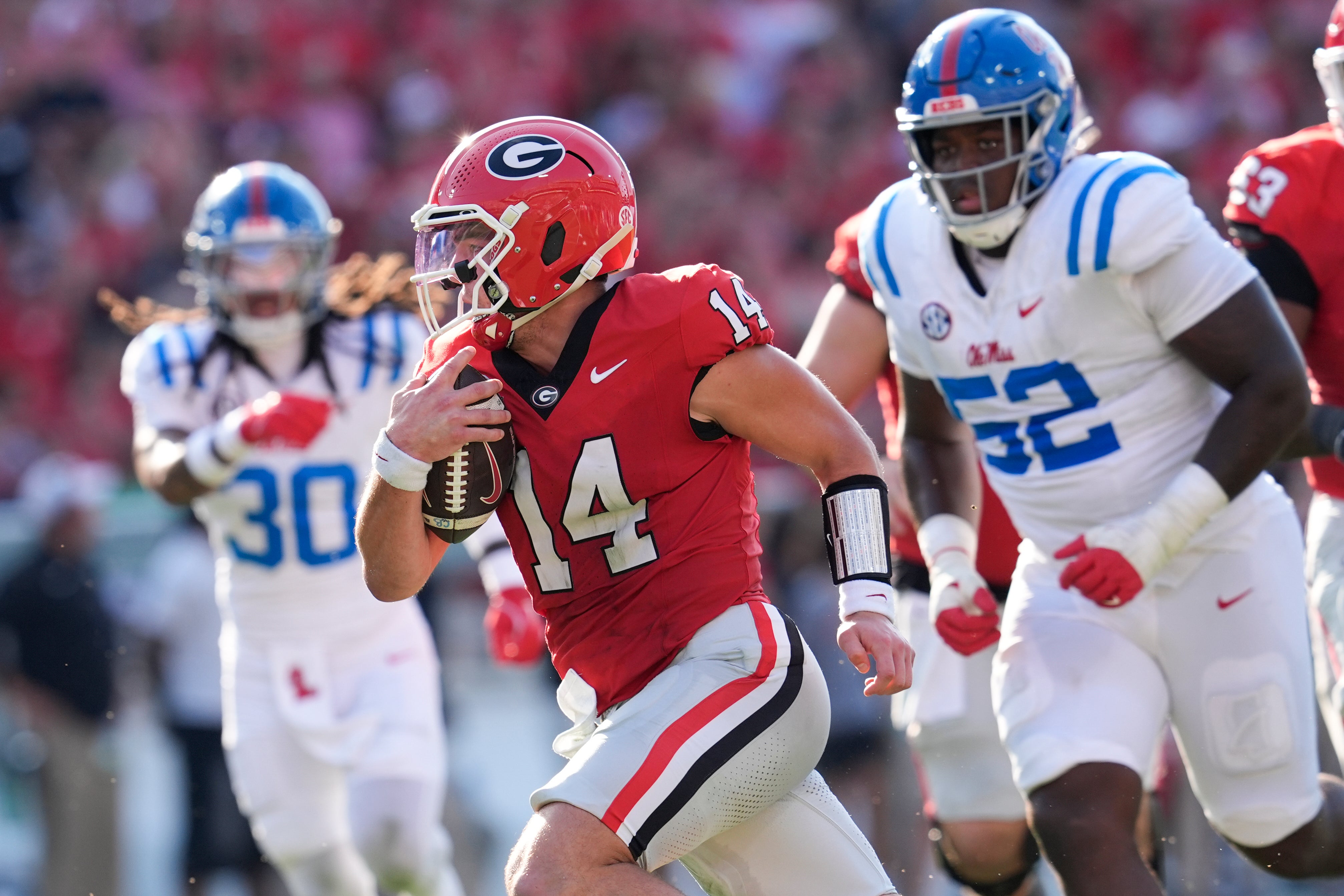 Georgia Bulldogs quarterback Gunner Stockton (14) runs the ball for a touchdown against Mississippi Rebels defensive tackle Will Echoles (52) during the first half of the game at Sanford Stadium.