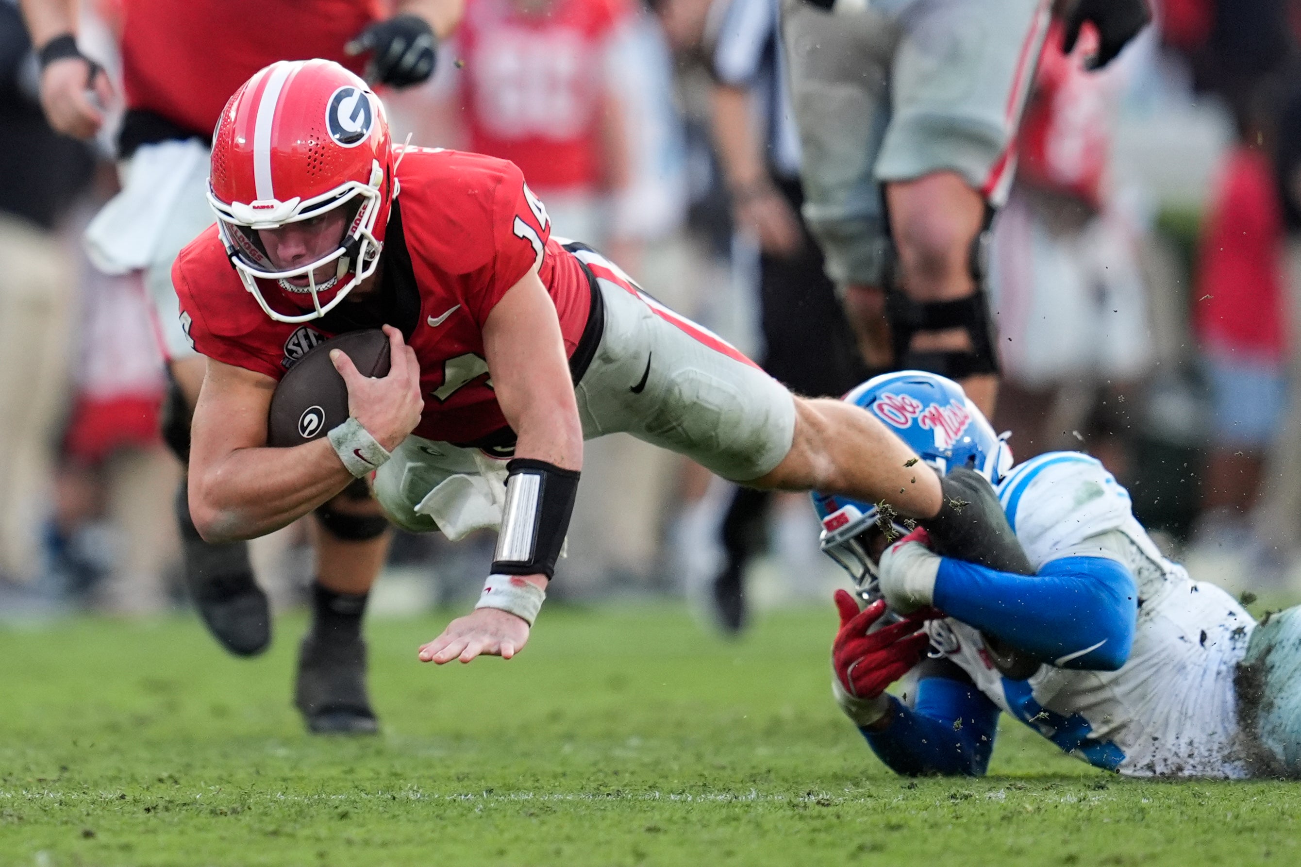 Oct 18, 2025; Athens, Georgia, USA; Georgia Bulldogs quarterback Gunner Stockton (14) is brought down by Mississippi Rebels linebacker Suntarine Perkins (4) during the fourth quarter of the game at Sanford Stadium.