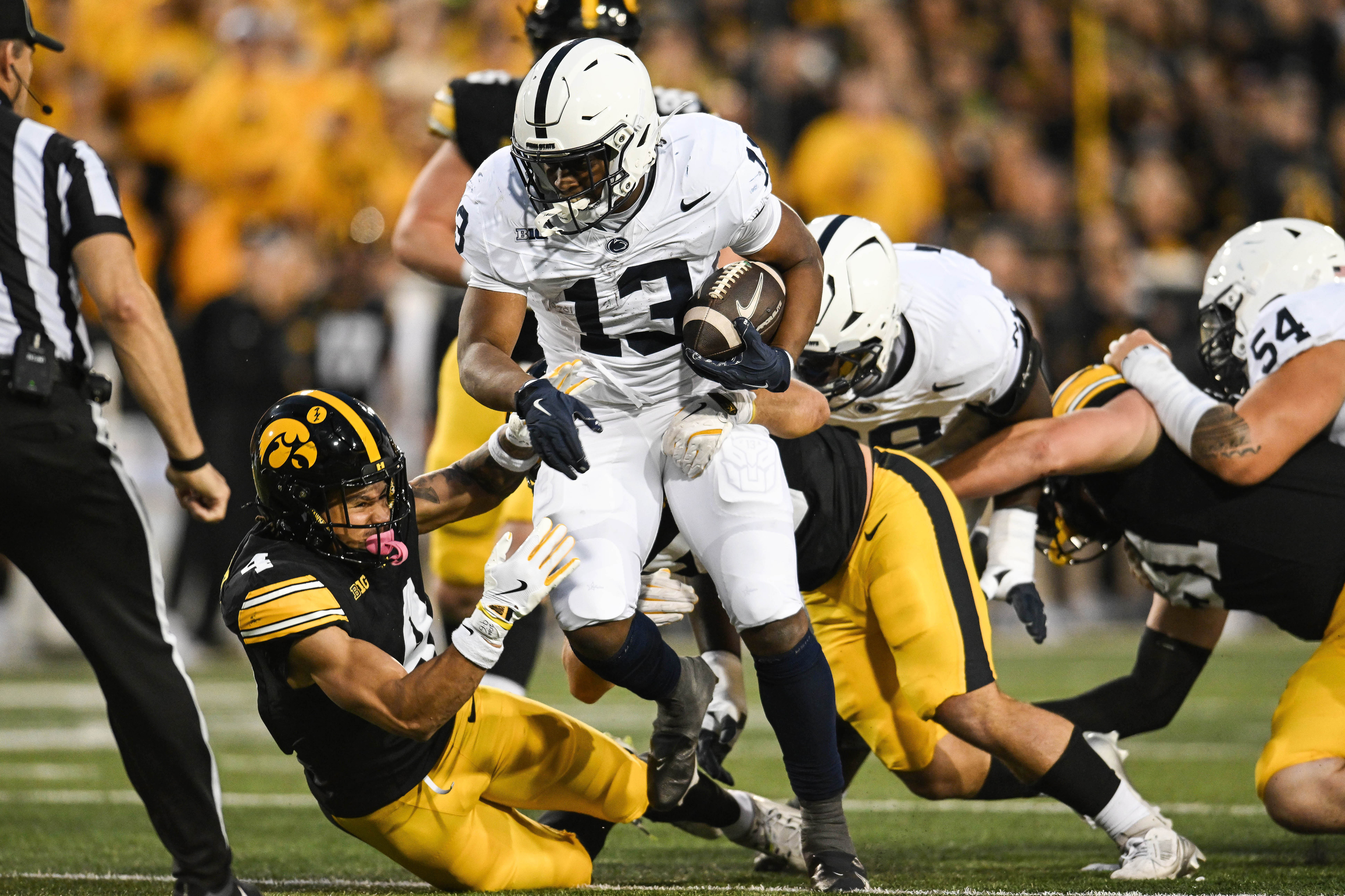 Oct 18, 2025; Iowa City, Iowa, USA; Penn State Nittany Lions linebacker Tony Rojas (13) runs the ball as Iowa Hawkeyes defensive back Koen Entringer (4) and linebacker Jayden Montgomery (36) make the tackle during the first quarter at Kinnick Stadium. Mandatory Credit: Jeffrey Becker-Imagn Images