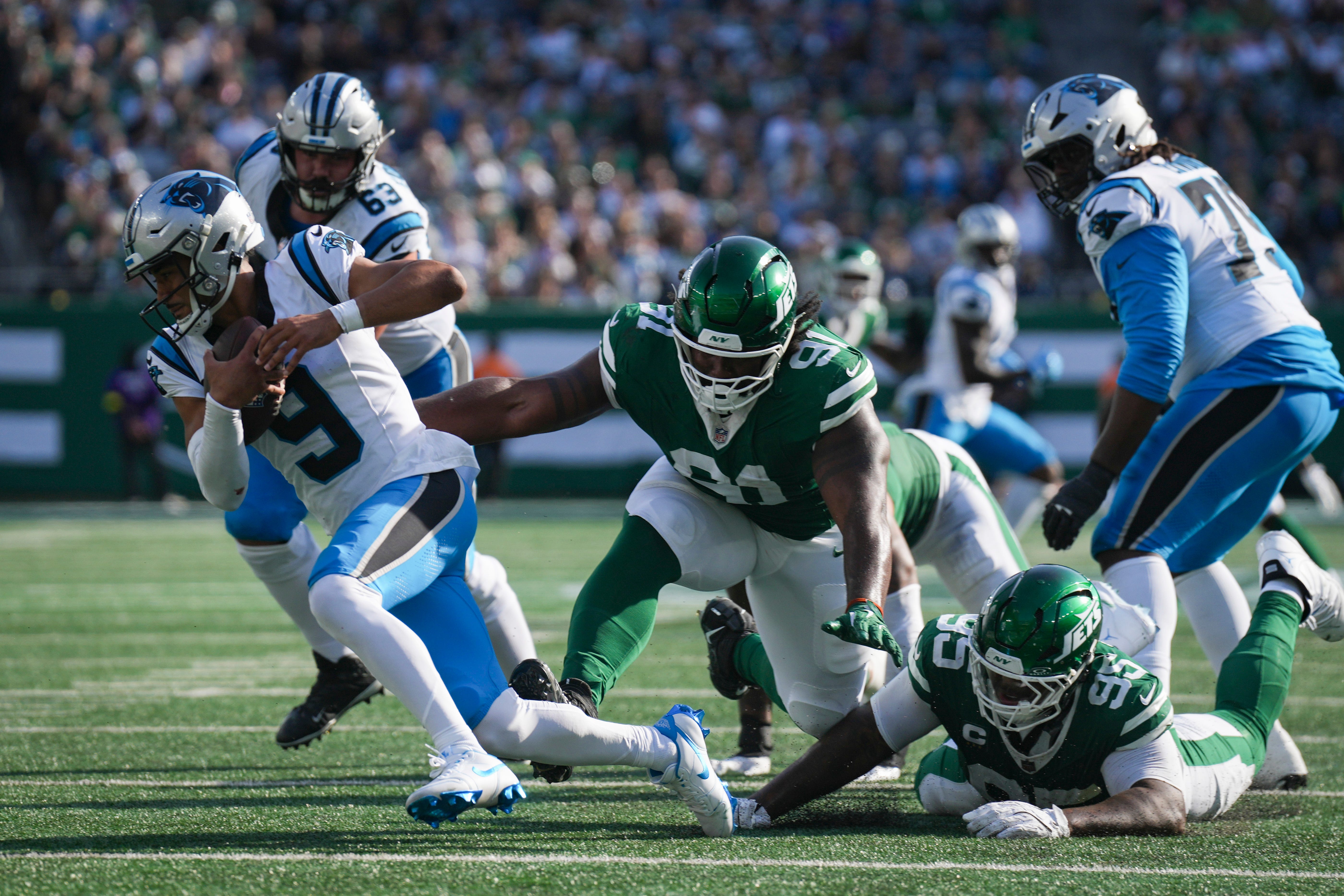 New York Jets defensive lineman Jowon Briggs (91) trips Carolina Panthers quarterback Bryce Young (9) during a game at MetLife Stadium, Oct 19, 2025, East Rutherford, NJ, USA.