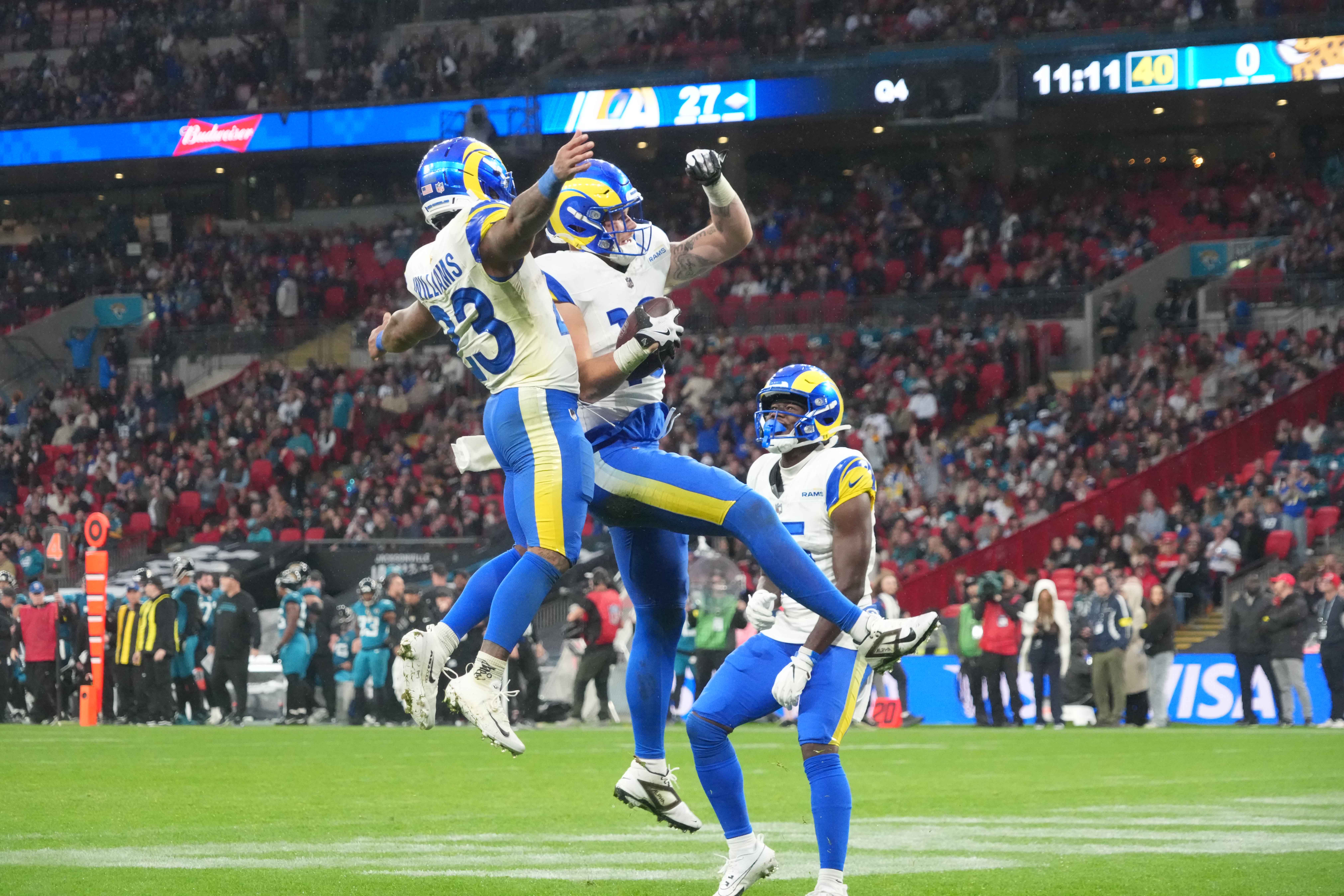 Oct 19, 2025; London, United Kingdom; Los Angeles Rams tight end Terrance Ferguson (18) celebrates with running back Kyren Williams (23) as wide receiver Konata Mumpfield (15) watches after scoring on a 31-yard touchdown reception in the fourth quarter against the Jacksonville Jaguars during a NFL International Series game at Wembley Stadium.