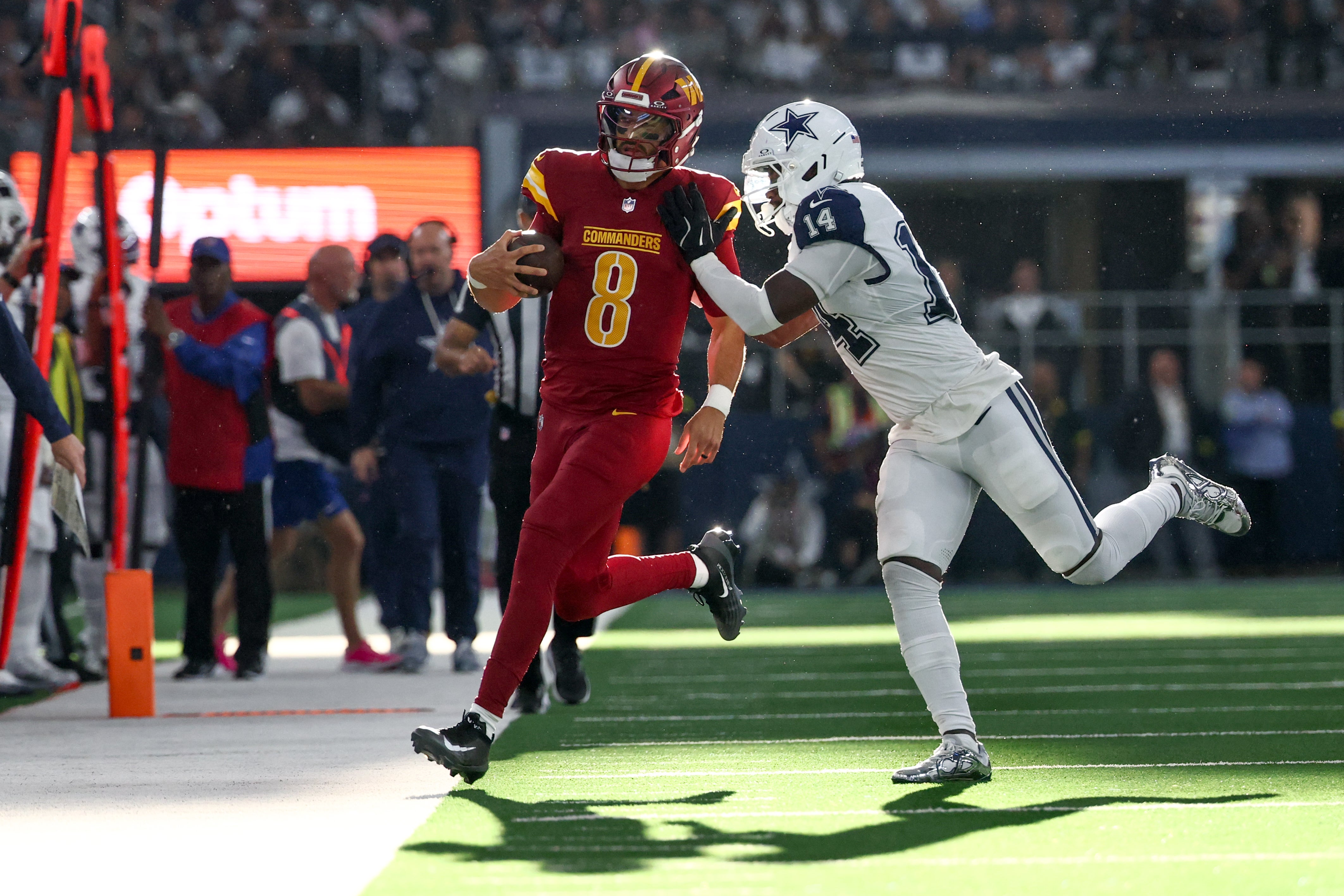 Oct 19, 2025; Arlington, Texas, USA; Dallas Cowboys safety Markquese Bell (14) pushes Washington Commanders quarterback Marcus Mariota (8) out of bounds during the third quarter of the game at AT&T Stadium. Mandatory Credit: Kevin Jairaj-Imagn Images