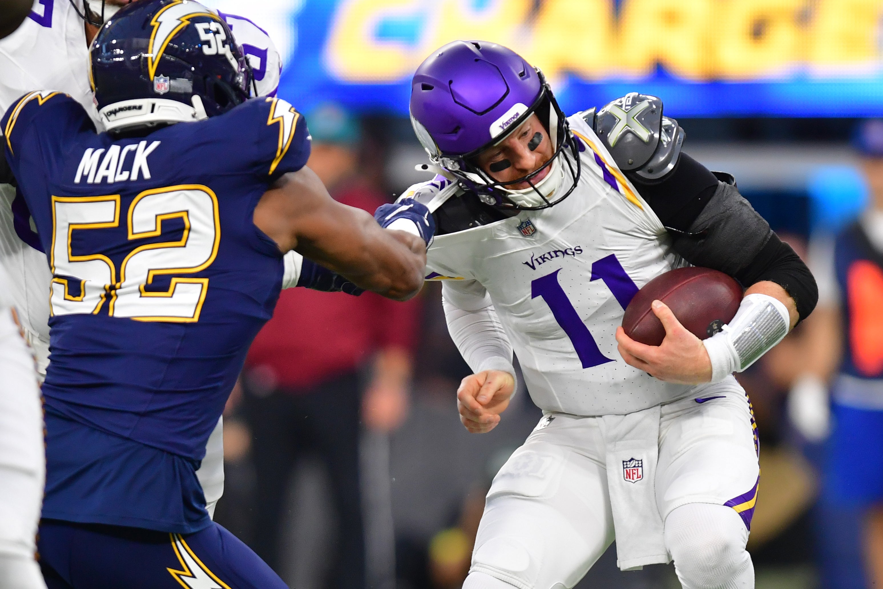 Oct 23, 2025; Inglewood, California, USA; Los Angeles Chargers linebacker Khalil Mack (52) tackles Minnesota Vikings quarterback Carson Wentz (11) during the first half at SoFi Stadium.