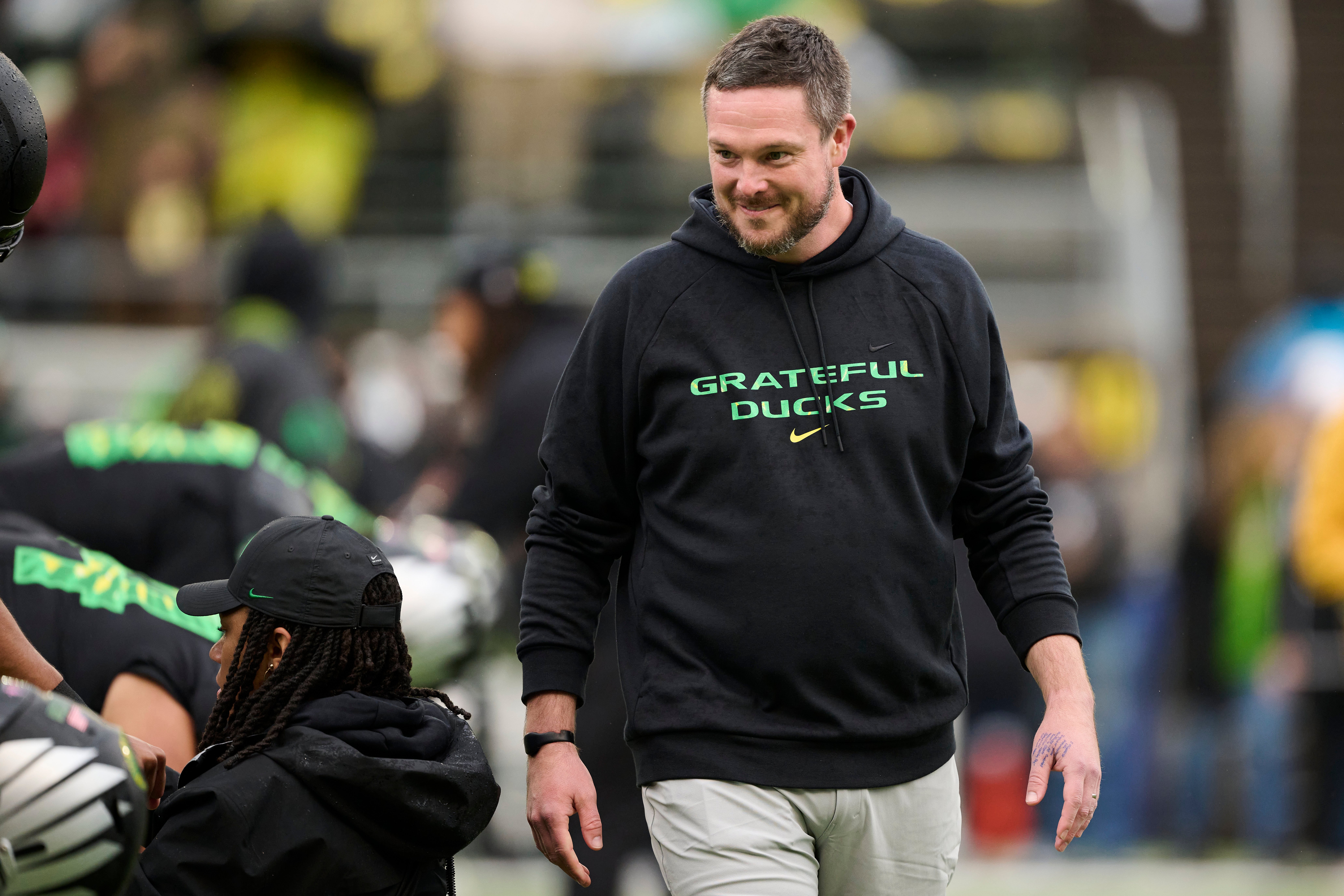 Oct 25, 2025; Eugene, Oregon, USA; Oregon Ducks head coach Dan Lanning encourages players during warm ups before a game against the Wisconsin Badgers at Autzen Stadium. The Ducks are wearing uniforms celebrating the Grateful Dead. Mandatory Credit: Troy Wayrynen-Imagn Images