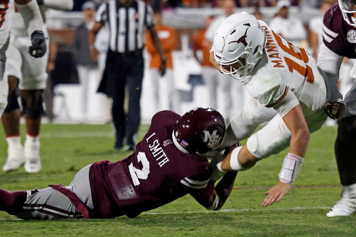 Oct 25, 2025; Starkville, Mississippi, USA; Texas Longhorns quarterback Arch Manning (16) runs the ball as Mississippi State Bulldogs defensive back Isaac Smith (2) makes the tackle during overtime at Davis Wade Stadium at Scott Field. Mandatory Credit: Petre Thomas-Imagn Images