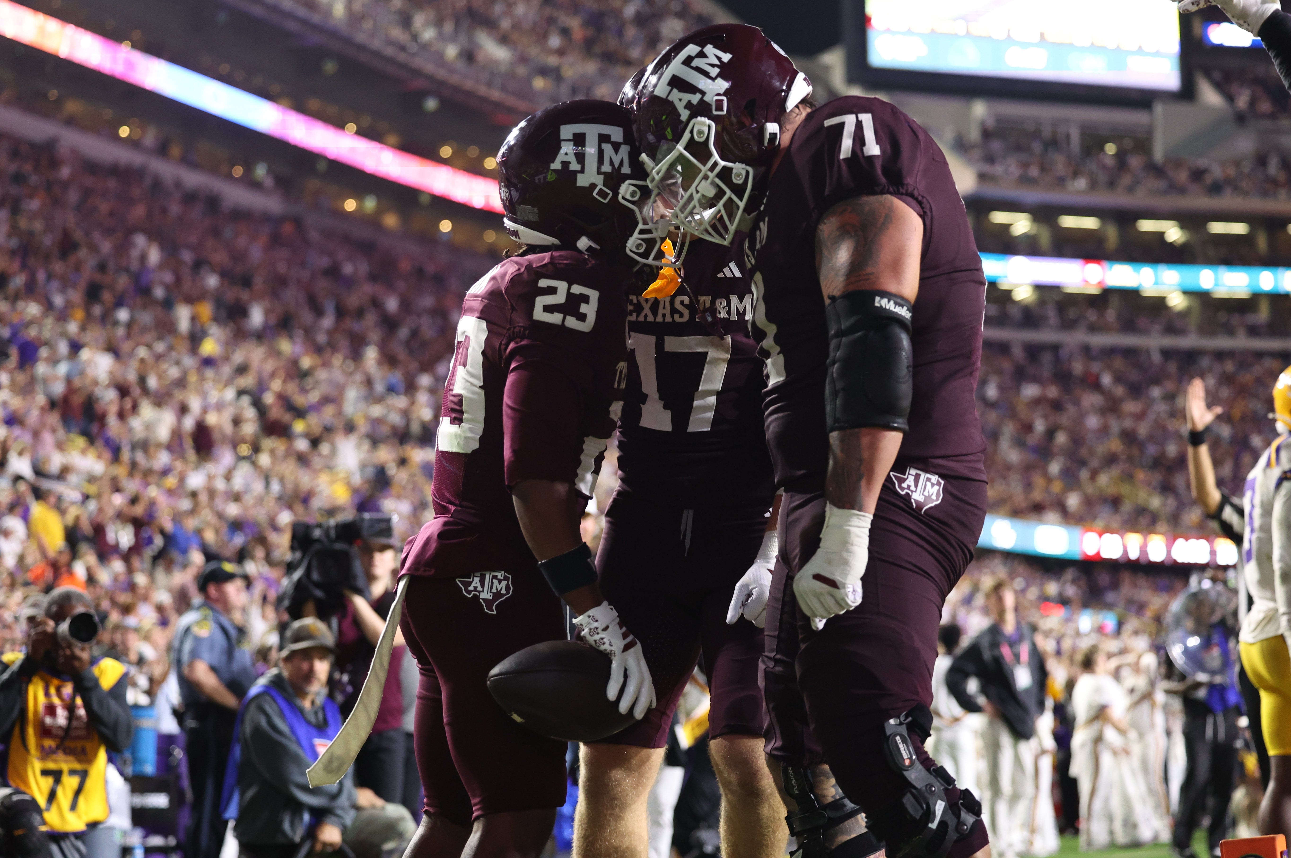Oct 25, 2025; Baton Rouge, Louisiana, USA; Texas A&M Aggies running back Jamarion Morrow (23) celebrates with offensive lineman Chase Bisontis (71) and tight end Theo Melin Ohrstrom (17) after a touchdown during the second half against the Louisiana State Tigers at Tiger Stadium.