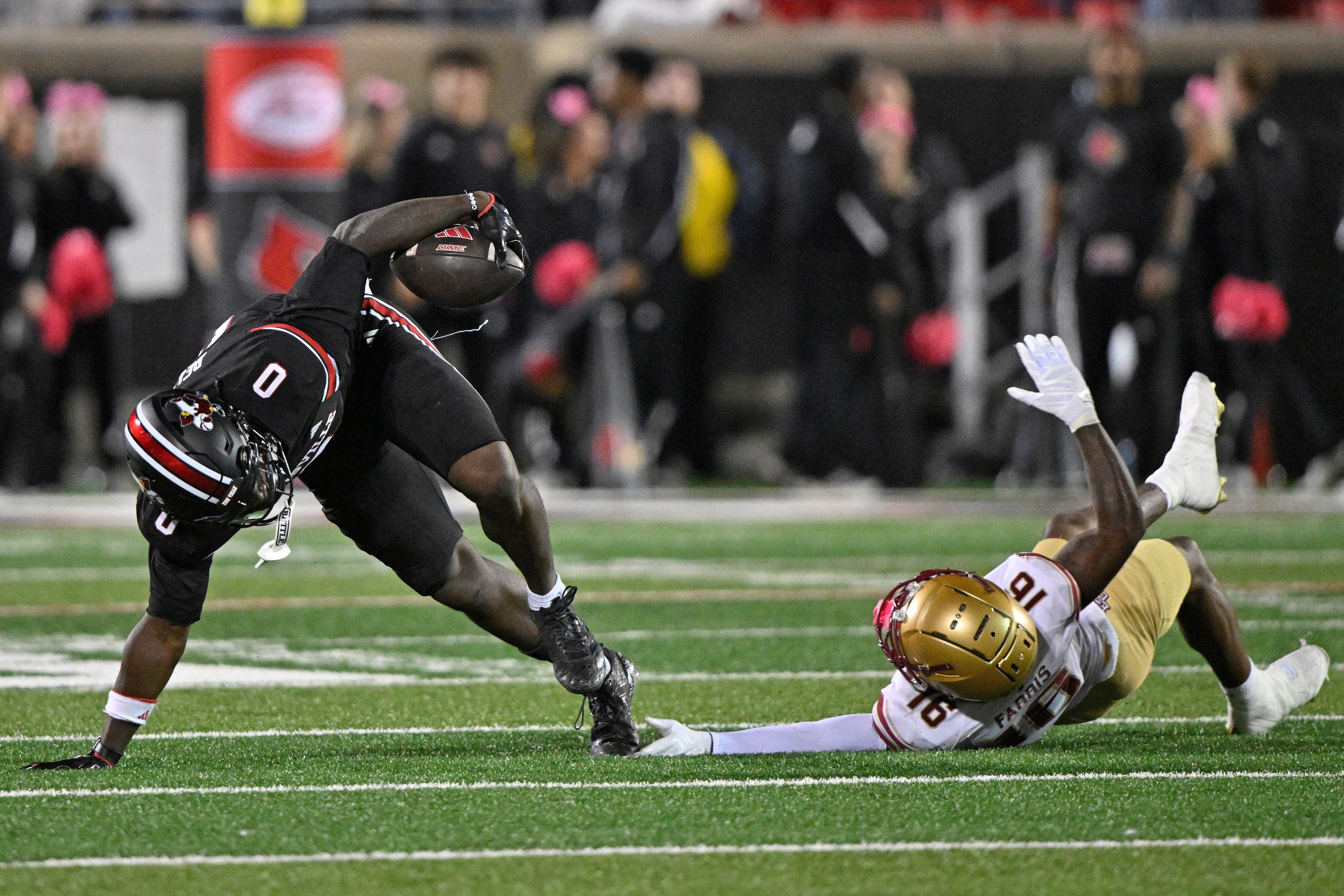 Oct 25, 2025; Louisville, Kentucky, USA; Louisville Cardinals wide receiver Chris Bell (0) avoids the tackle from Boston College Eagles defensive back Isaiah Farris (16) during the second half at L&N Federal Credit Union Stadium. Mandatory Credit: Jamie Rhodes-Imagn Images
