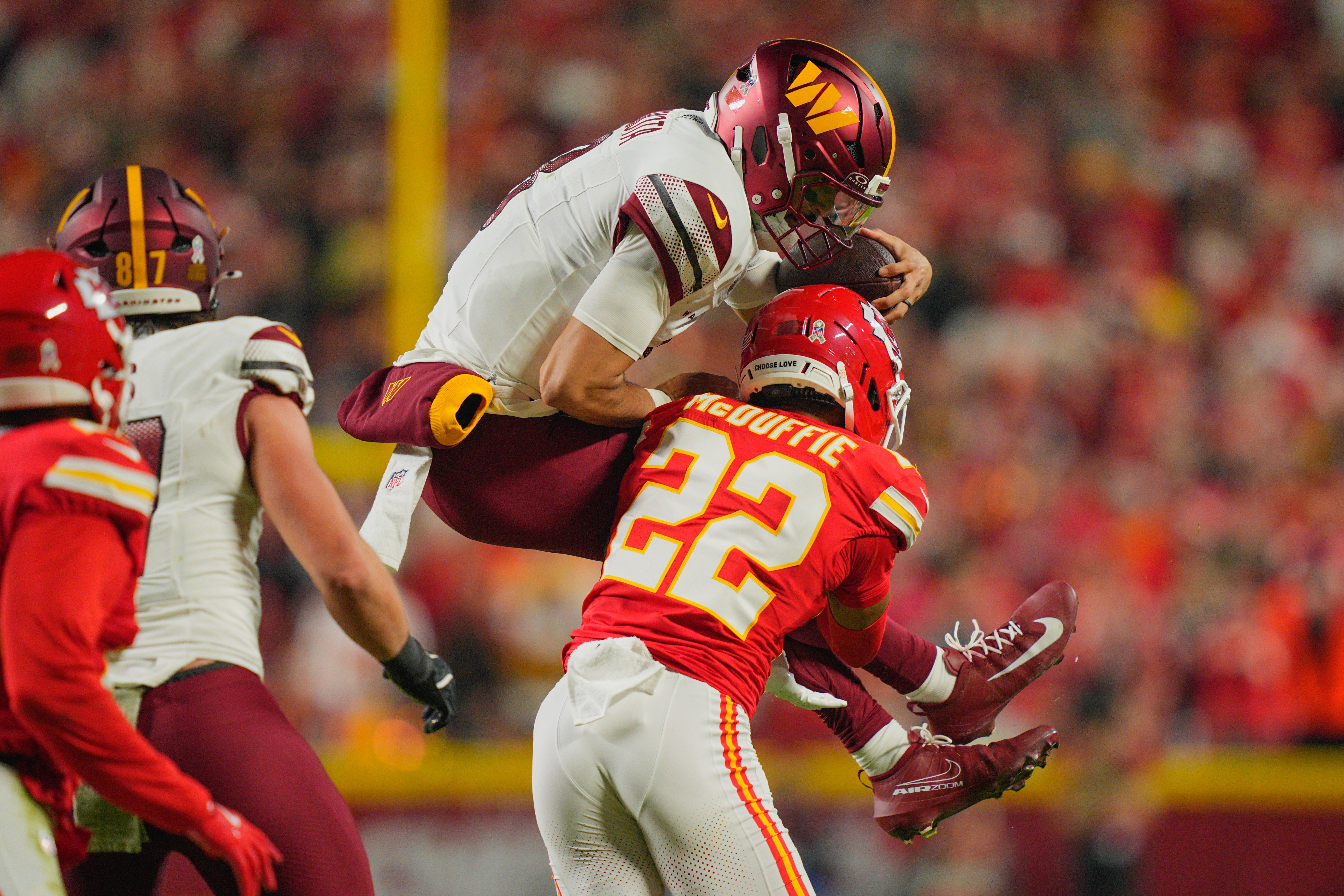 Kansas City Chiefs cornerback Trent McDuffie (22) tackles Washington Commanders quarterback Marcus Mariota (8)