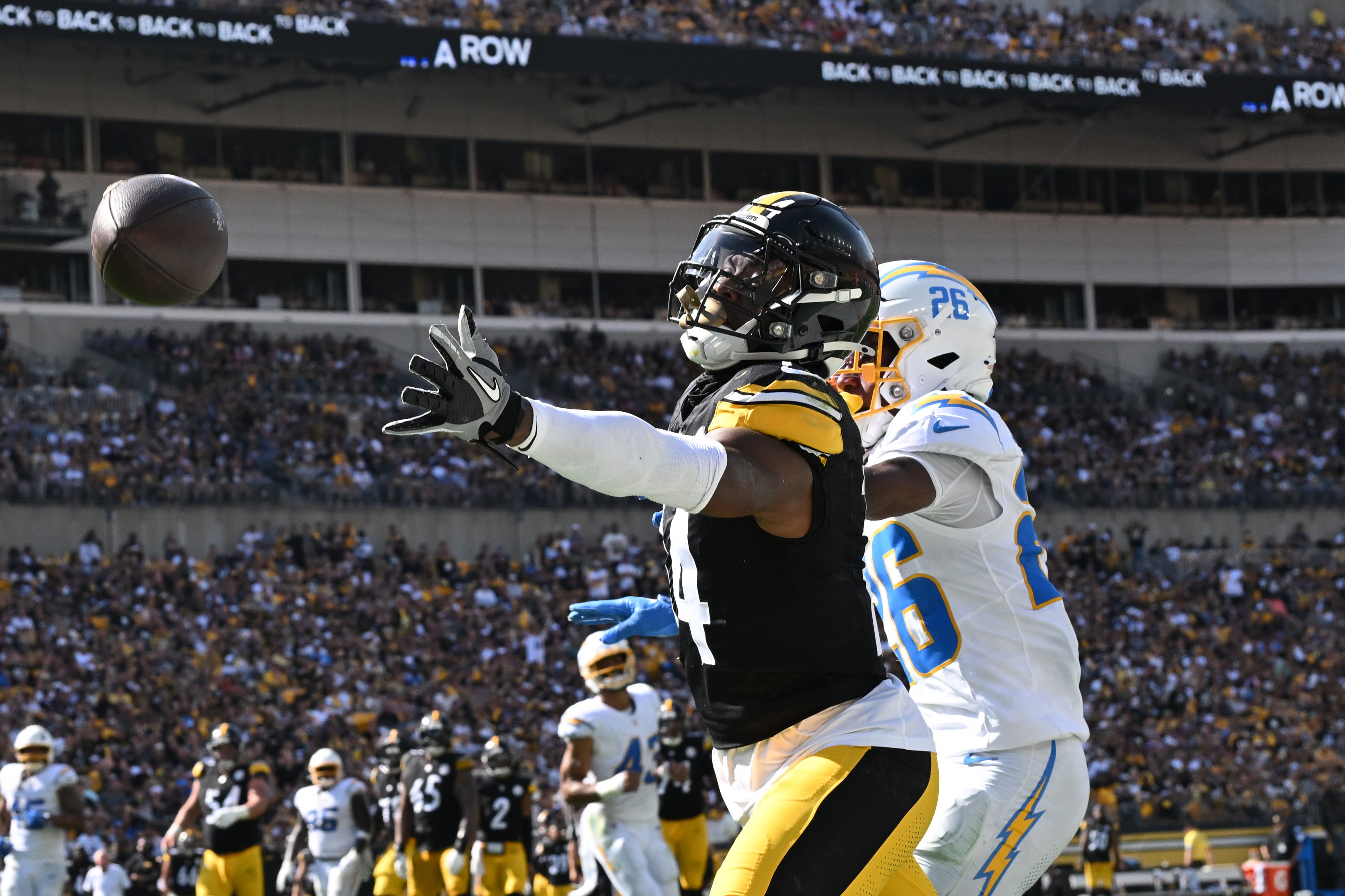 Sep 22, 2024; Pittsburgh, Pennsylvania, USA; Pittsburgh Steelers wide receiver George Pickens (14) reaches for a pass while being defended by Los Angeles Chargers cornerback Asante Samuel Jr. (26) during the second half at Acrisure Stadium.
