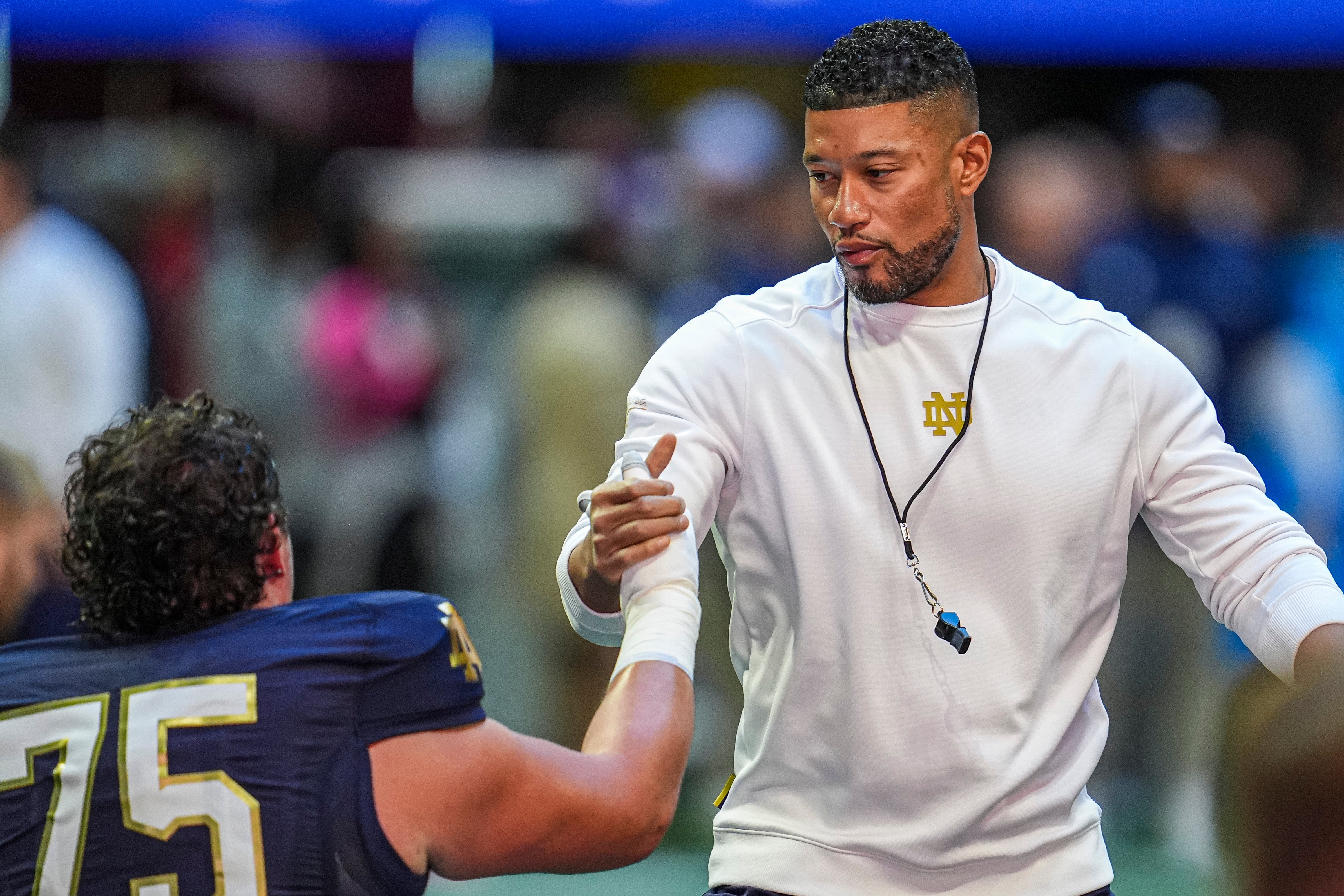 Oct 19, 2024; Atlanta, Georgia, USA; Notre Dame Fighting Irish head coach Marcus Freeman greets players before the game against the Georgia Tech Yellow Jackets at Mercedes-Benz Stadium. Mandatory Credit: Dale Zanine-Imagn Images