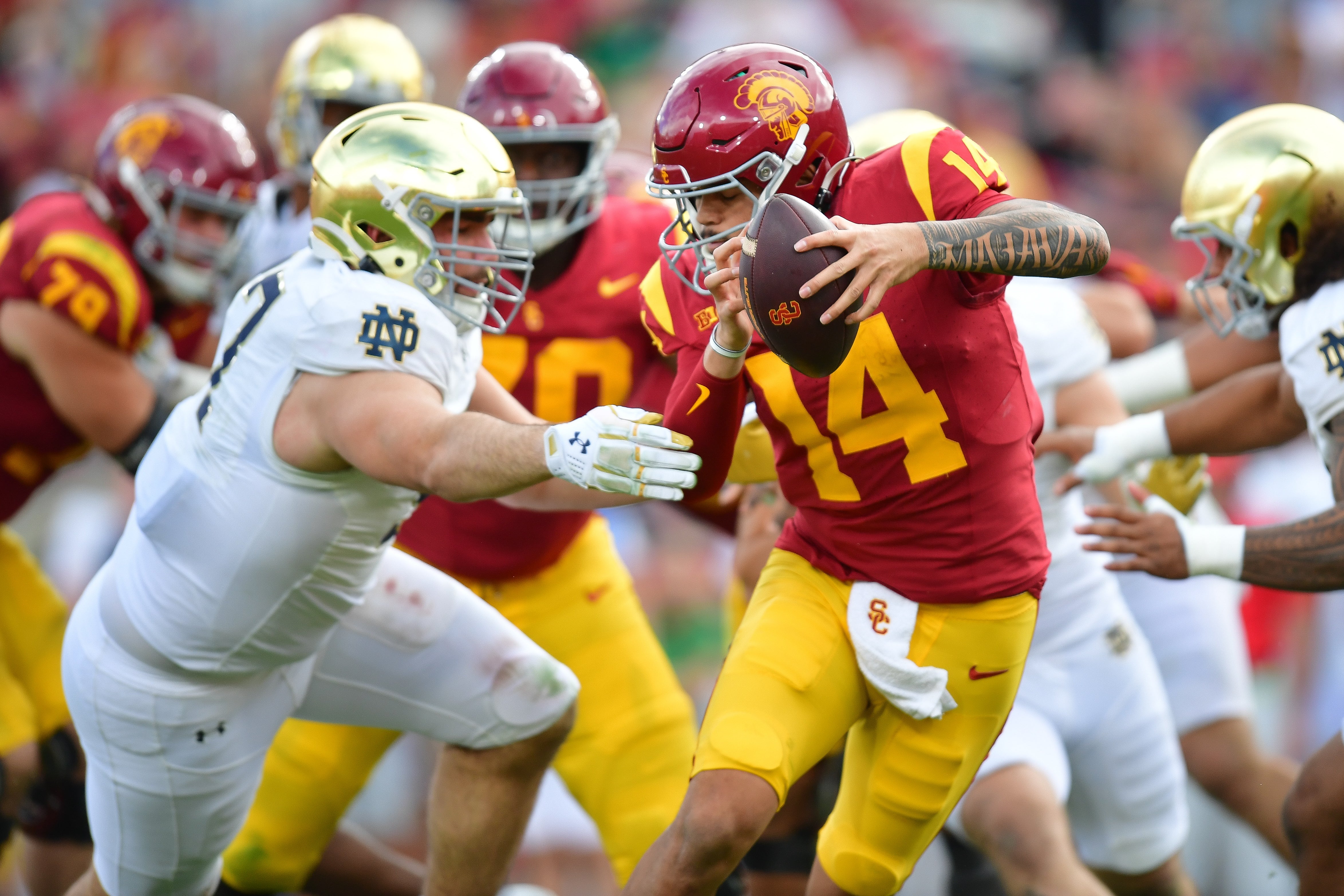 Nov 30, 2024; Los Angeles, California, USA; Southern California Trojans quarterback Jayden Maiava (14) moves the ball as Notre Dame Fighting Irish defensive lineman Gabriel Rubio (97) moves in during the first half at the Los Angeles Memorial Coliseum. Mandatory Credit: Gary A. Vasquez-Imagn Images