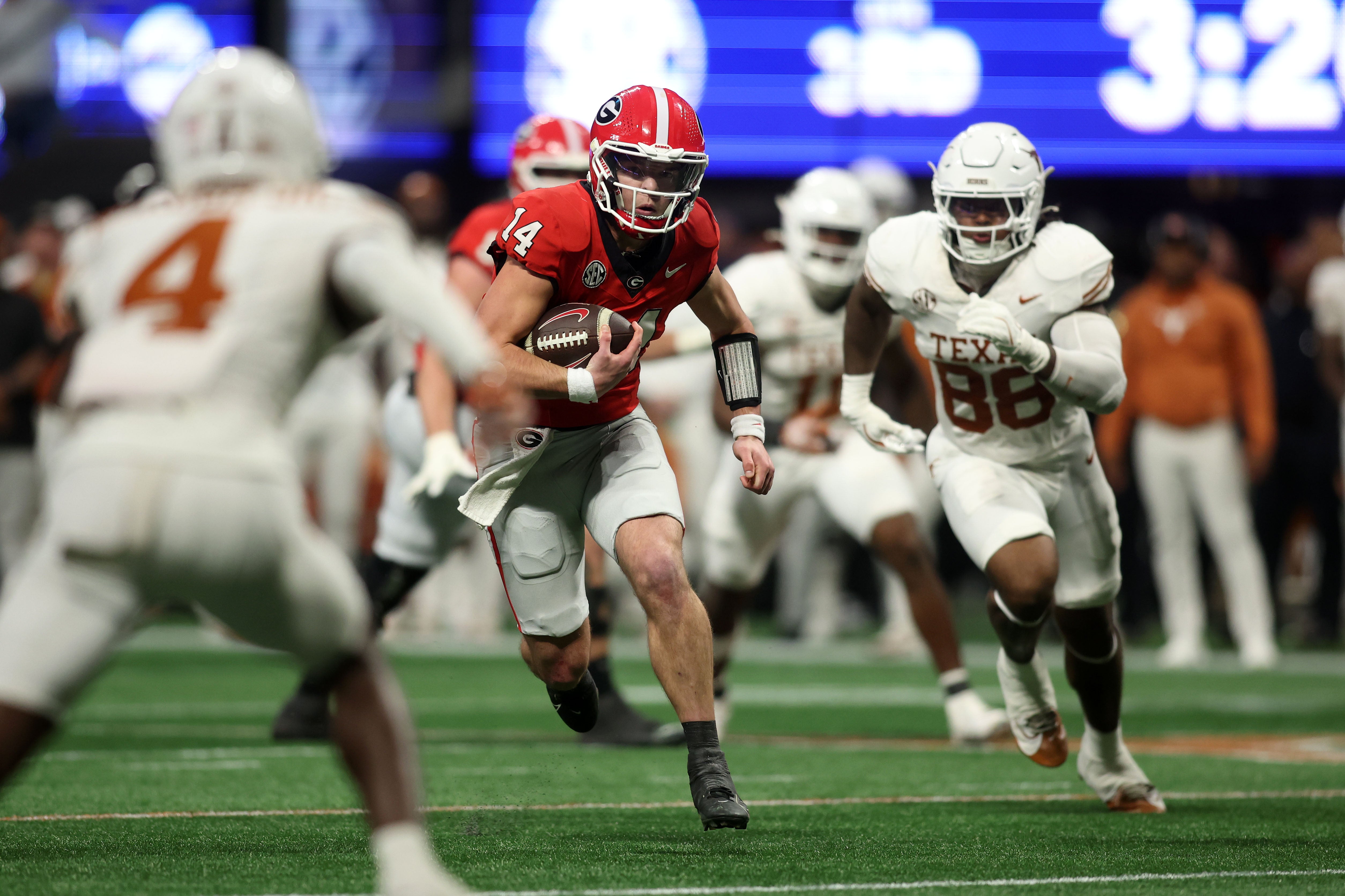 Georgia Bulldogs quarterback Gunner Stockton (14) rushes the ball against the Texas Longhorns during the second half in the 2024 SEC Championship game at Mercedes-Benz Stadium.