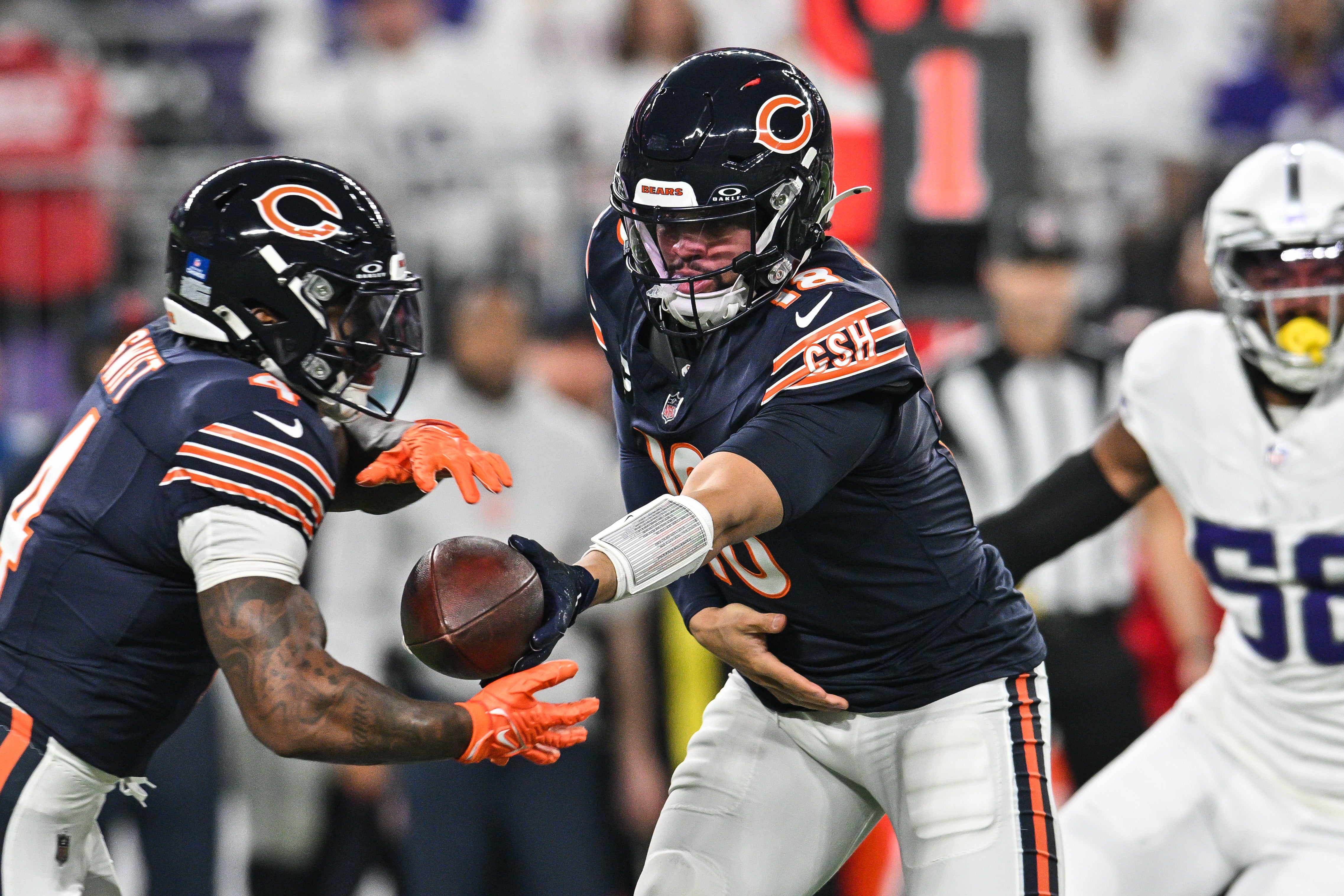 Dec 16, 2024; Minneapolis, Minnesota, USA; Chicago Bears quarterback Caleb Williams (18) hands the ball off to running back D'Andre Swift (4) during the first quarter at U.S. Bank Stadium.