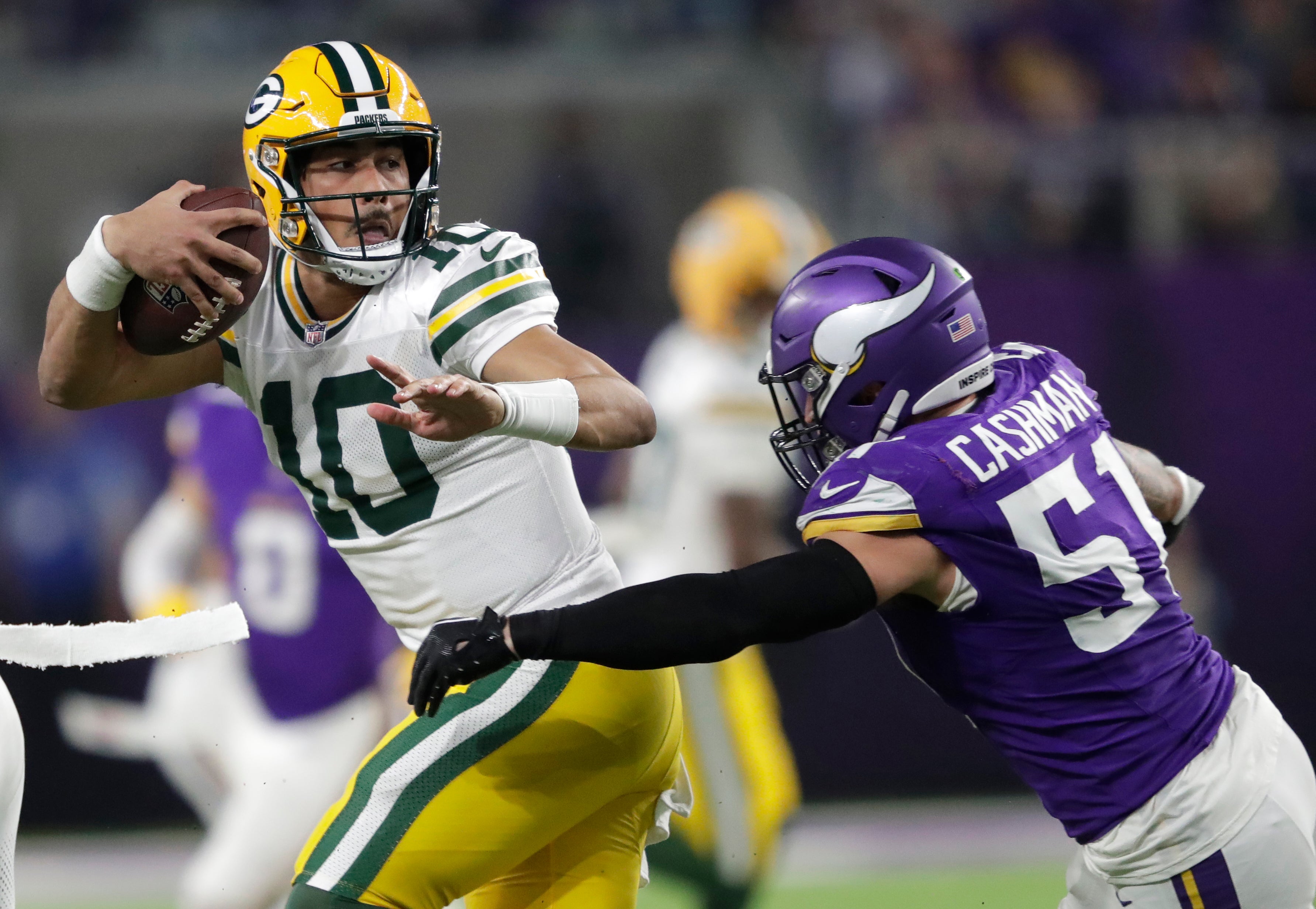 Dec 29, 2024; Minneapolis, Minnesota, USA; Green Bay Packers quarterback Jordan Love (10) is tackled by Minnesota Vikings linebacker Blake Cashman (51) in the fourth quarter at U.S. Bank Stadium.