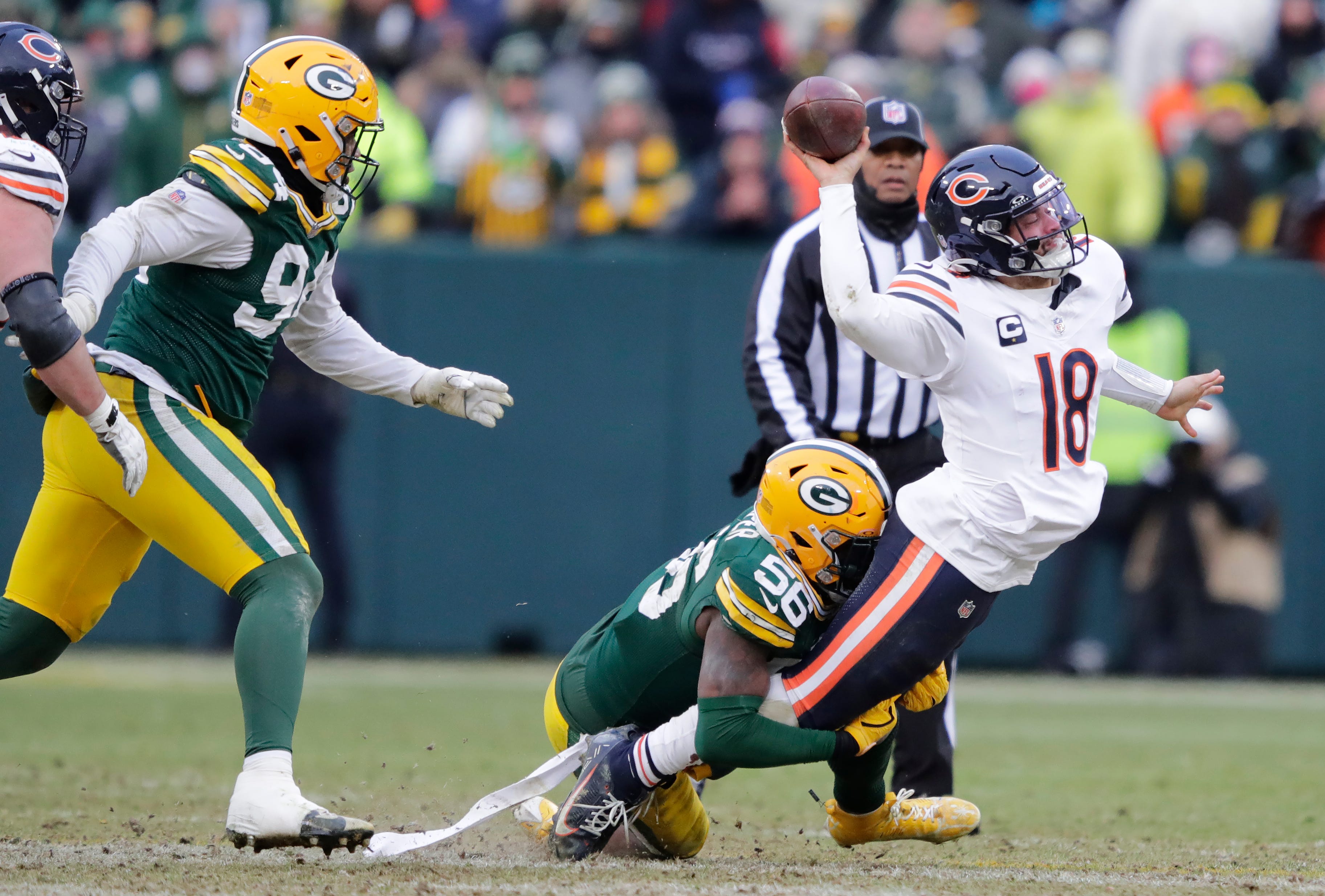 Chicago Bears quarterback Caleb Williams (18) throws an incomplete pass as he is tackled by Green Bay Packers linebacker Edgerrin Cooper (56) in the fourth quarter during their football game Sunday, January 5, 2025, at Lambeau Field in Green Bay, Wisconsin.