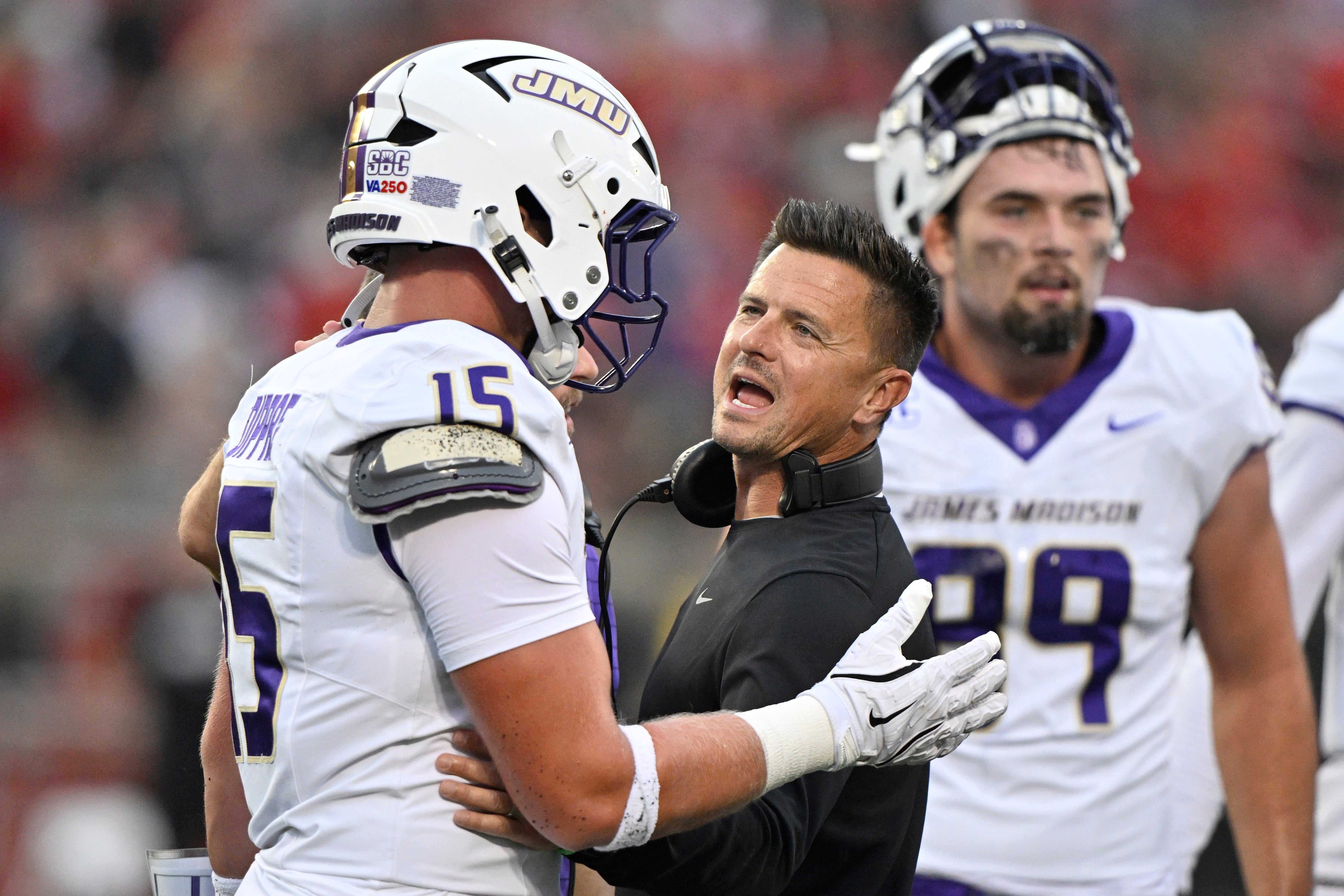 Sep 5, 2025; Louisville, Kentucky, USA; James Madison Dukes head coach Bob Chesney talks with tight end Lacota Dippre (15) during the first quarter against the Louisville Cardinals at L&N Federal Credit Union Stadium. Mandatory Credit: Jamie Rhodes-Imagn Images