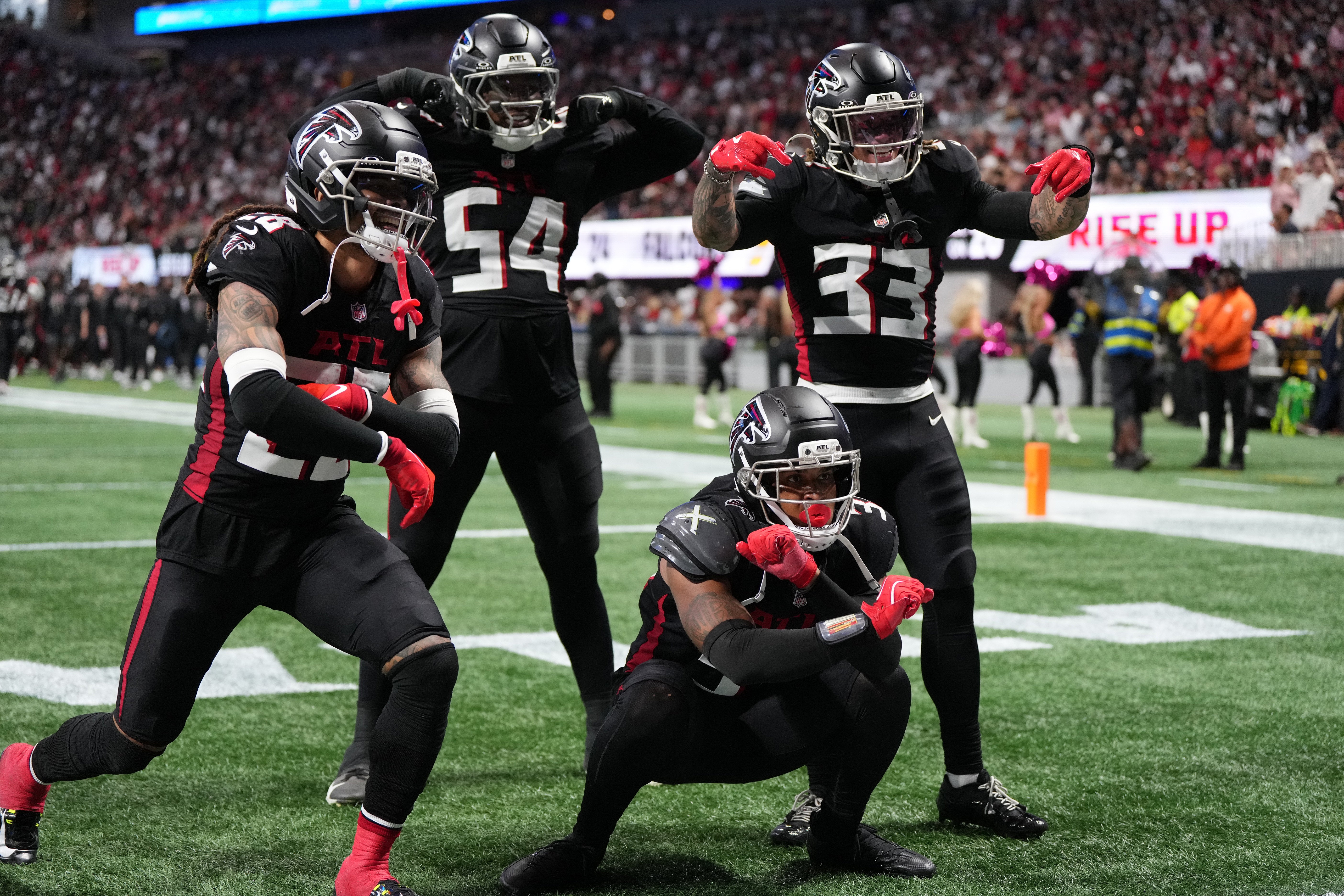 Sep 28, 2025; Atlanta, Georgia, USA; Atlanta Falcons safety Xavier Watts (31) celebrates with cornerback Mike Ford (28), defensive end Brandon Dorlus (54) and safety Billy Bowman Jr. (33) after a play during the second half against the Washington Commanders at Mercedes-Benz Stadium. Mandatory Credit: Dale Zanine-Imagn Images