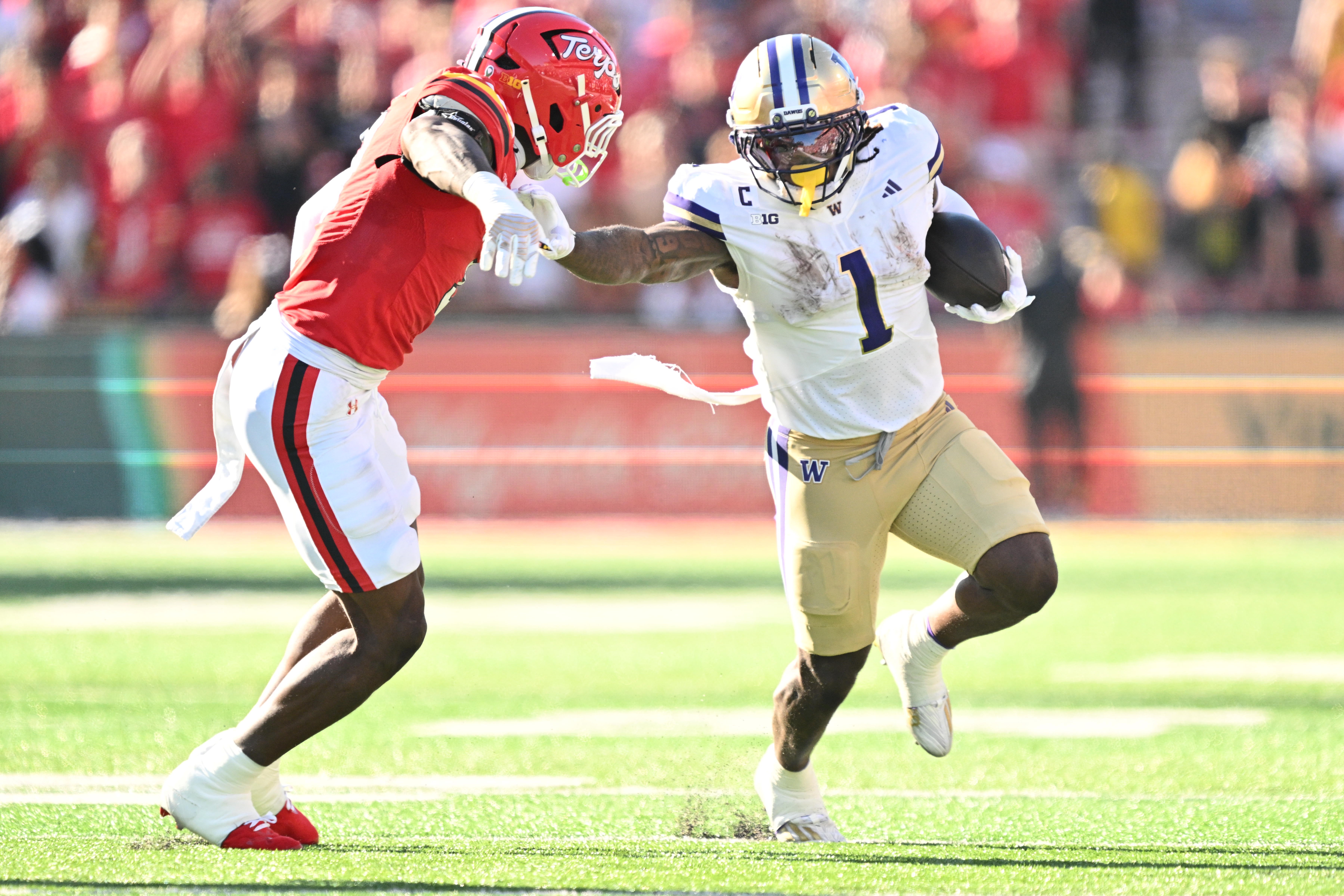 Oct 4, 2025; College Park, Maryland, USA; Washington Huskies running back Jonah Coleman (1) stiff arms Maryland Terrapins linebacker Trey Reddick (3) while picking up yardage in the first half at SECU Stadium.