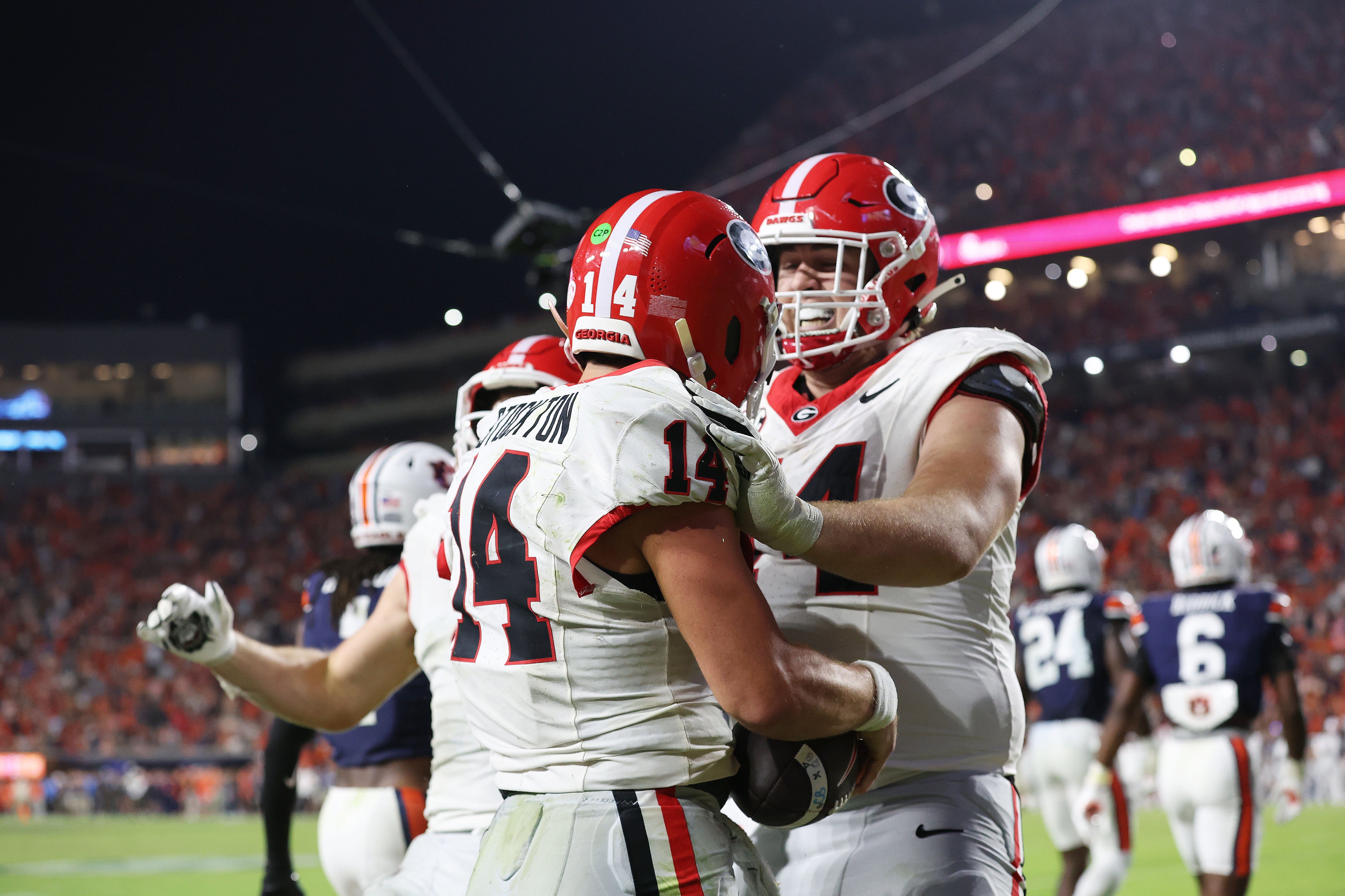 Georgia Bulldogs quarterback Gunner Stockton (14) celebrates a touchdown with offensive lineman Drew Bobo (74) during the fourth quarter against the Auburn Tigers at Jordan-Hare Stadium.