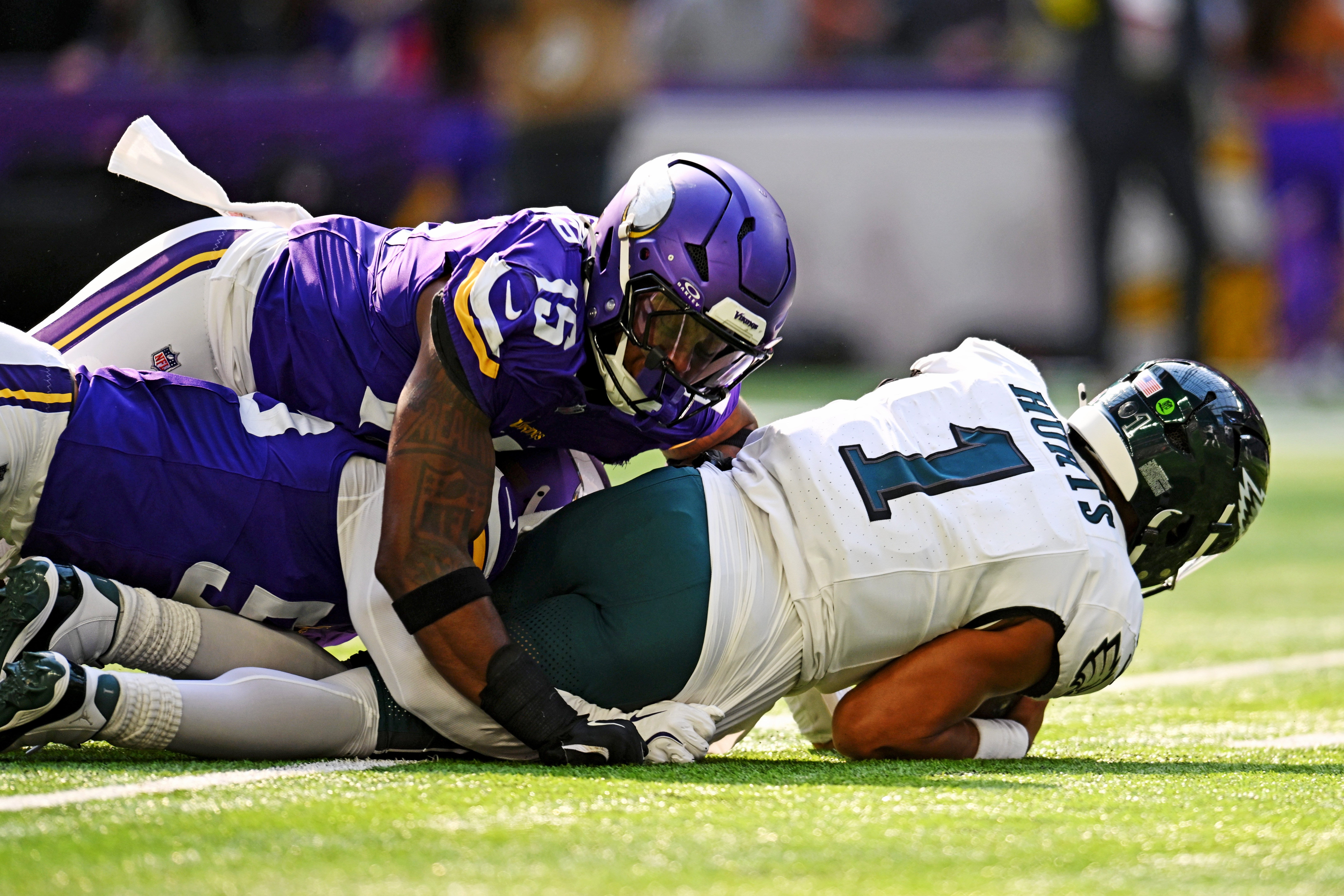 Oct 19, 2025; Minneapolis, Minnesota, USA; Philadelphia Eagles quarterback Jalen Hurts (1) is tackled by Minnesota Vikings linebacker Dallas Turner (15) during the second half at U.S. Bank Stadium.