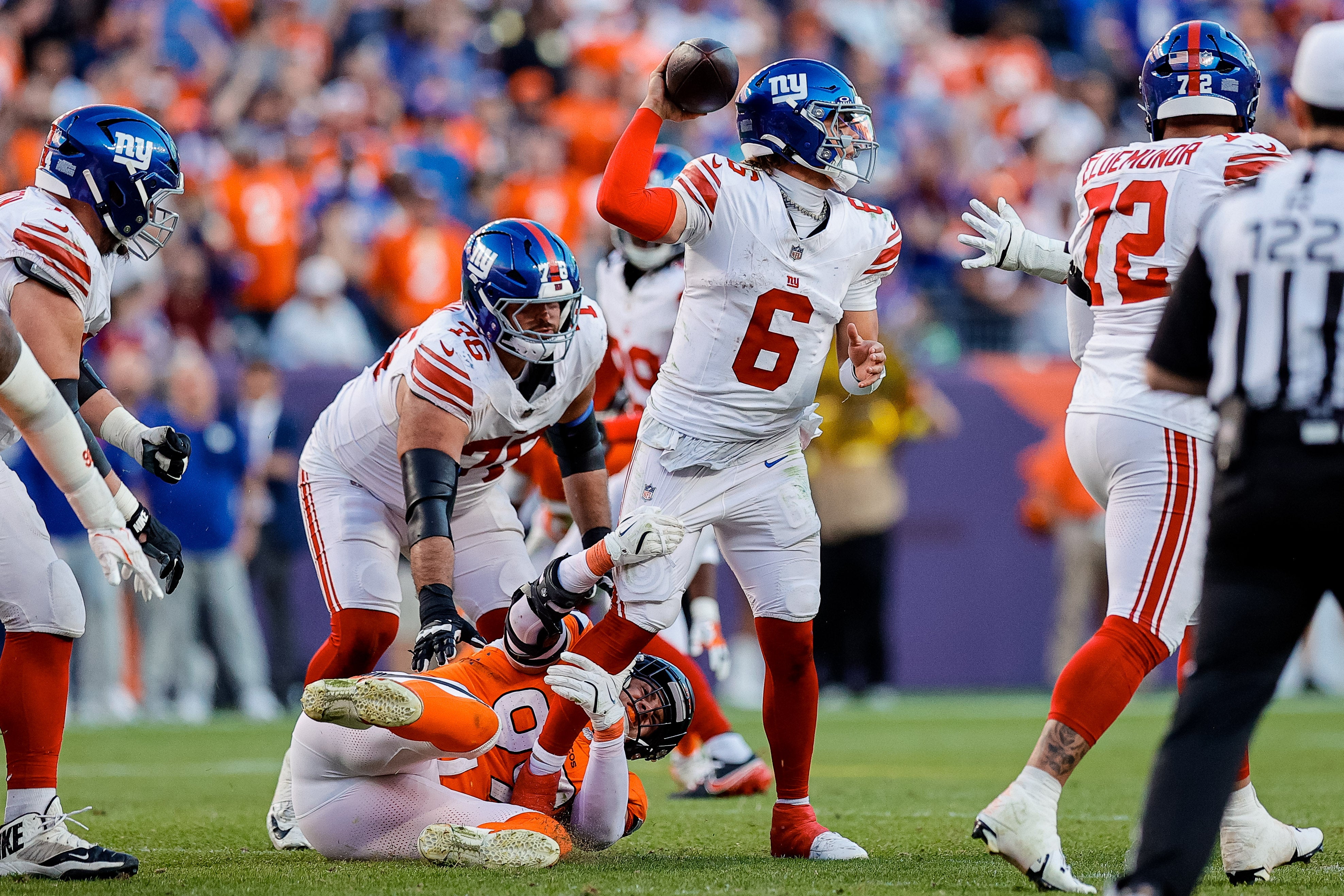 Oct 19, 2025; Denver, Colorado, USA; New York Giants quarterback Jaxson Dart (6) is sacked by Denver Broncos defensive end Zach Allen (99) as guard Jon Runyan Jr. (76) defends in the fourth quarter at Empower Field at Mile High.