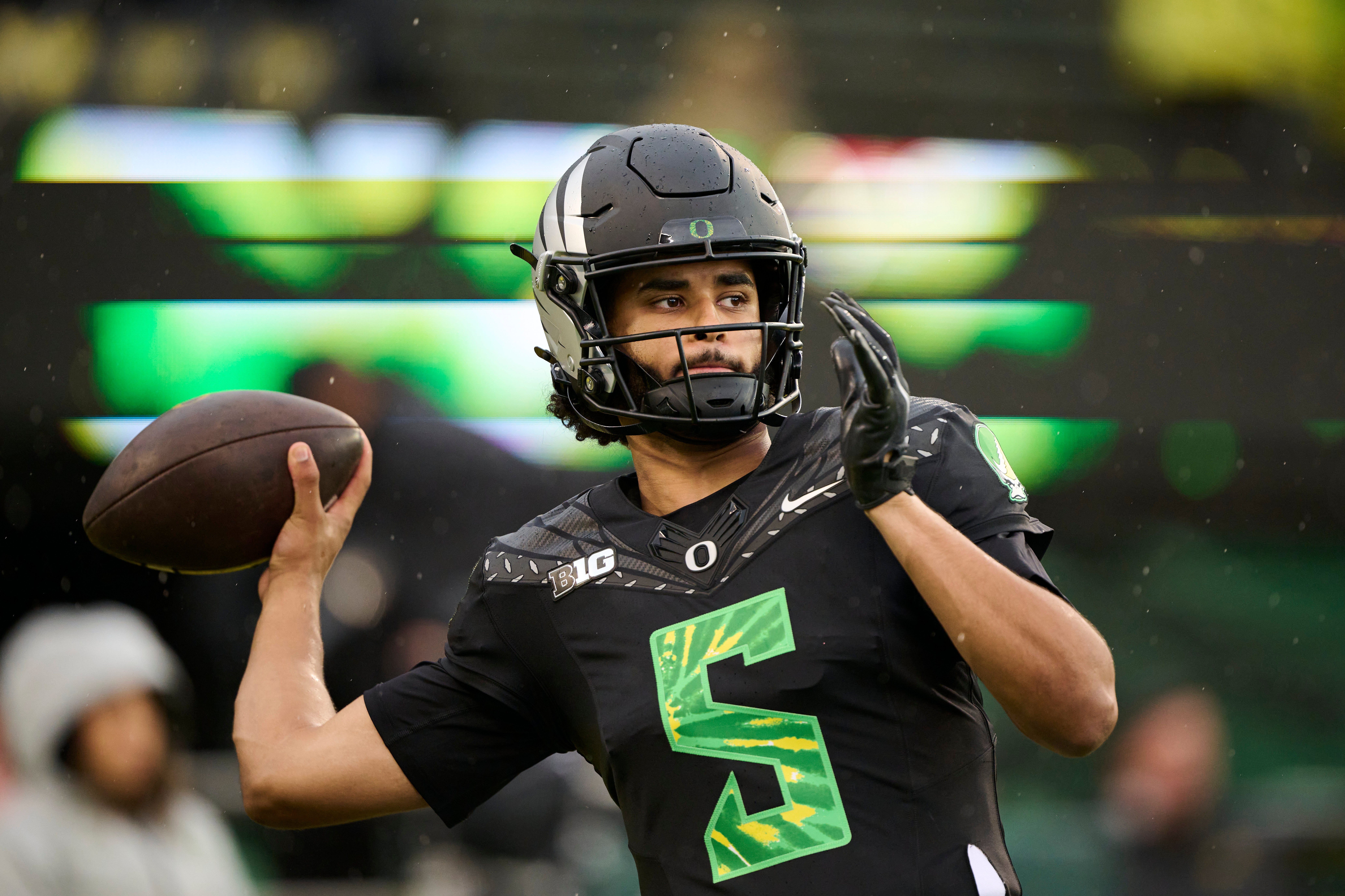 Oct 25, 2025; Eugene, Oregon, USA; Oregon Ducks quarterback Dante Moore (5) warms up before a game against the Wisconsin Badgers at Autzen Stadium. The Ducks are wearing uniforms celebrating the Grateful Dead. Mandatory Credit: Troy Wayrynen-Imagn Images