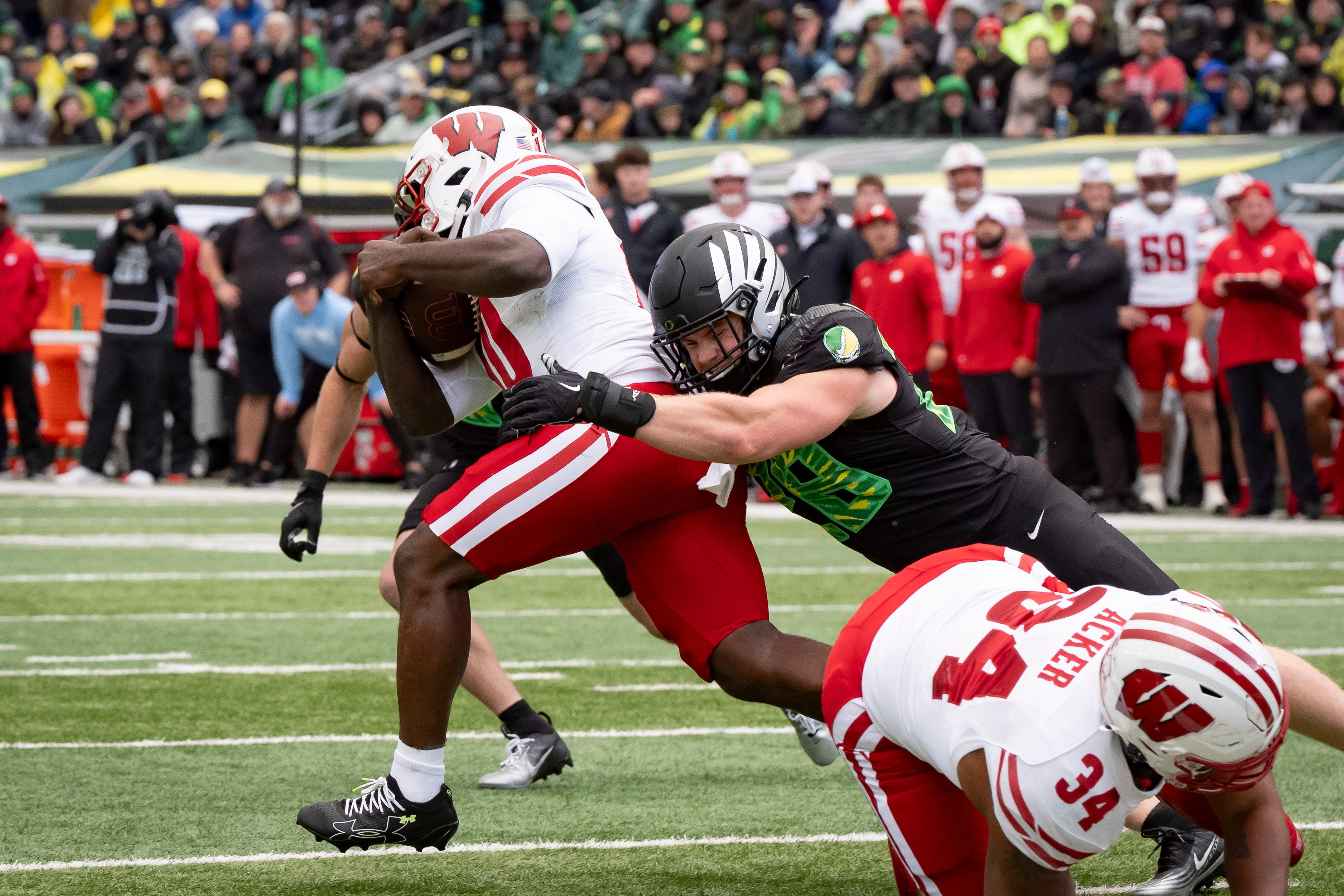 Oregon inside linebacker Bryce Boettcher wrangles Wisconsin running back Gideon Ituka as the Oregon Ducks host the Wisconsin Badgers on Oct. 25, 2025, at Autzen Stadium in Eugene, Oregon.