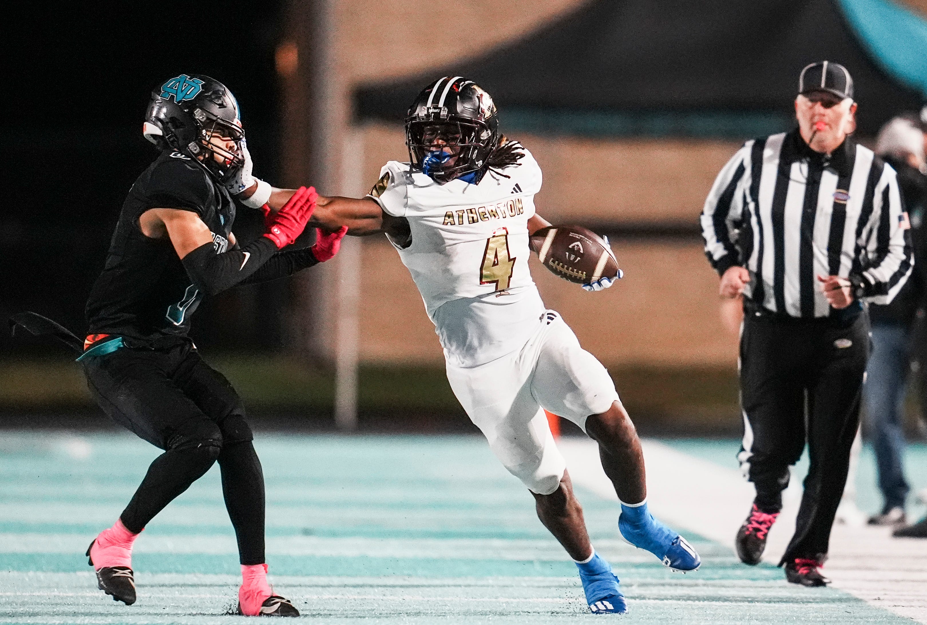 Atherton High School's Garyon Hobbs (4) put a stiff arm on North Oldham High School's Andrew Davis (0) while running for yardage as the Ravens rolled past North Oldham 42-13 KHSAA football on Friday night in Goshen, Kentucky. Hobbs had kick return touchdown in the second half. Oct. 31, 2025