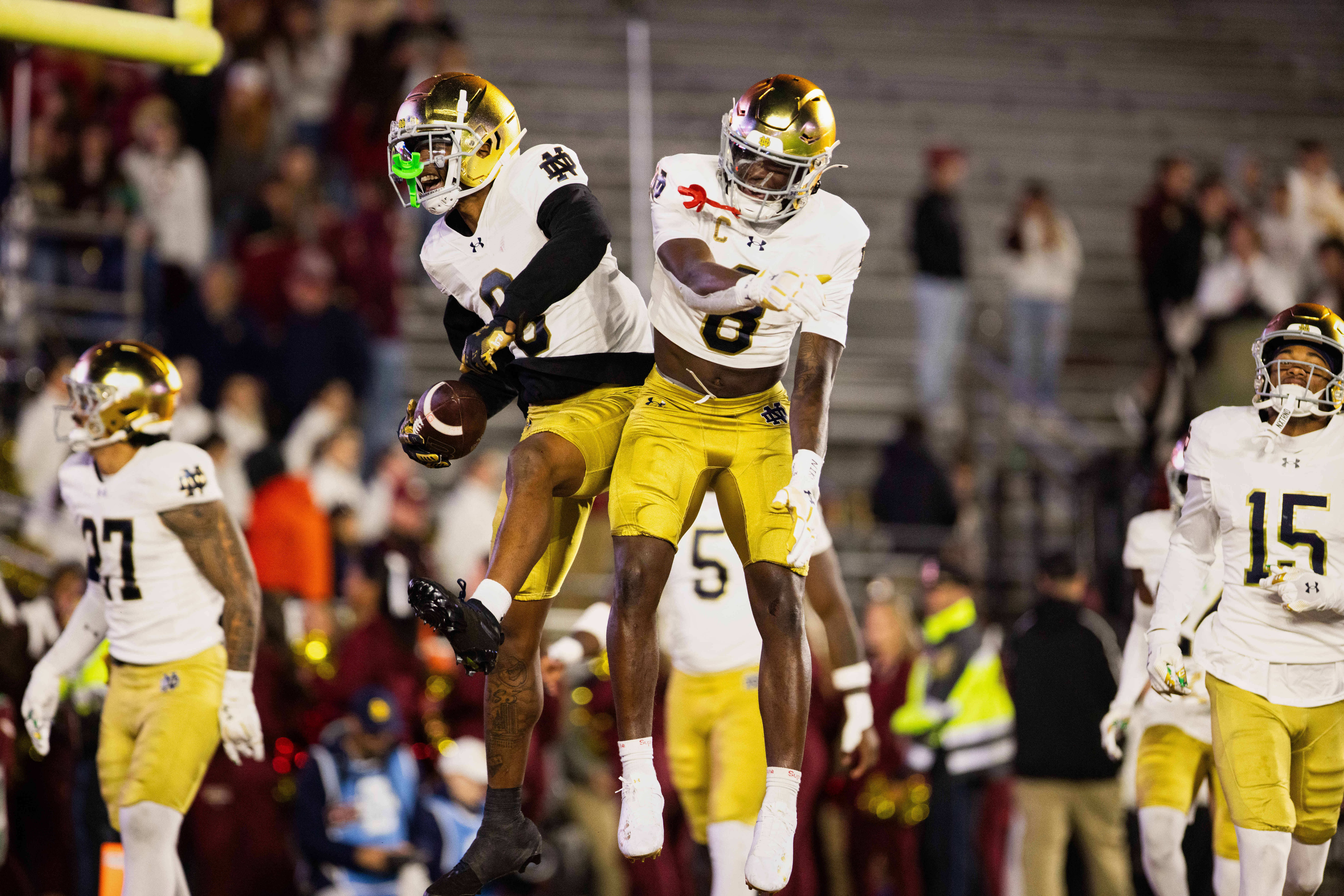 Nov 1, 2025; Chestnut Hill, Massachusetts, USA; Notre Dame safeties Tae Johnson (9) and Adon Shuler (8) leap and celebrate an interception in the fourth quarter against the Boston College Eagles at Alumni Stadium. Mandatory Credit: Edward Finan-Imagn Images