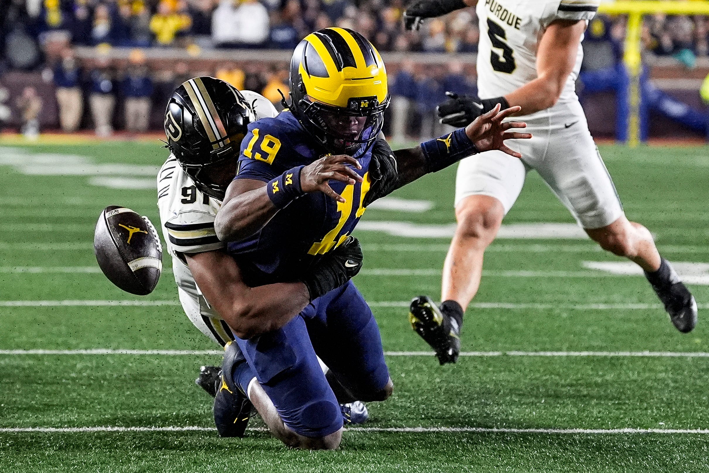 Michigan quarterback Bryce Underwood (19) fumbles the ball against Purdue defensive lineman CJ Nunnally (91) during the second half at Michigan Stadium in Ann Arbor on Saturday, November 1, 2025.