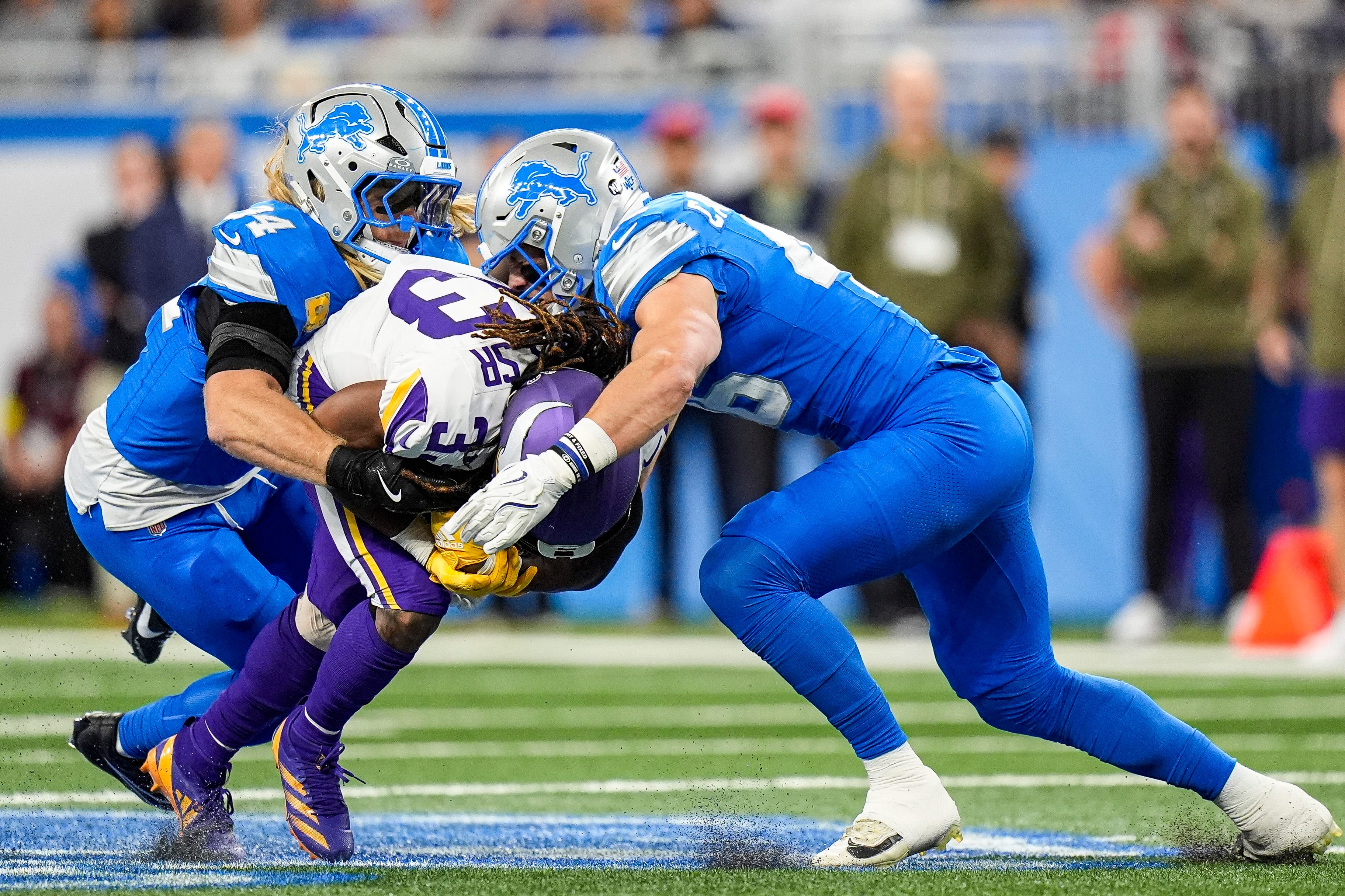 Detroit Lions linebacker Alex Anzalone (34) and linebacker Jack Campbell (46) tackle Minnesota Vikings running back Aaron Jones Sr. (33) during the first half at Ford Field in Detroit on Sunday, November 2, 2025.
