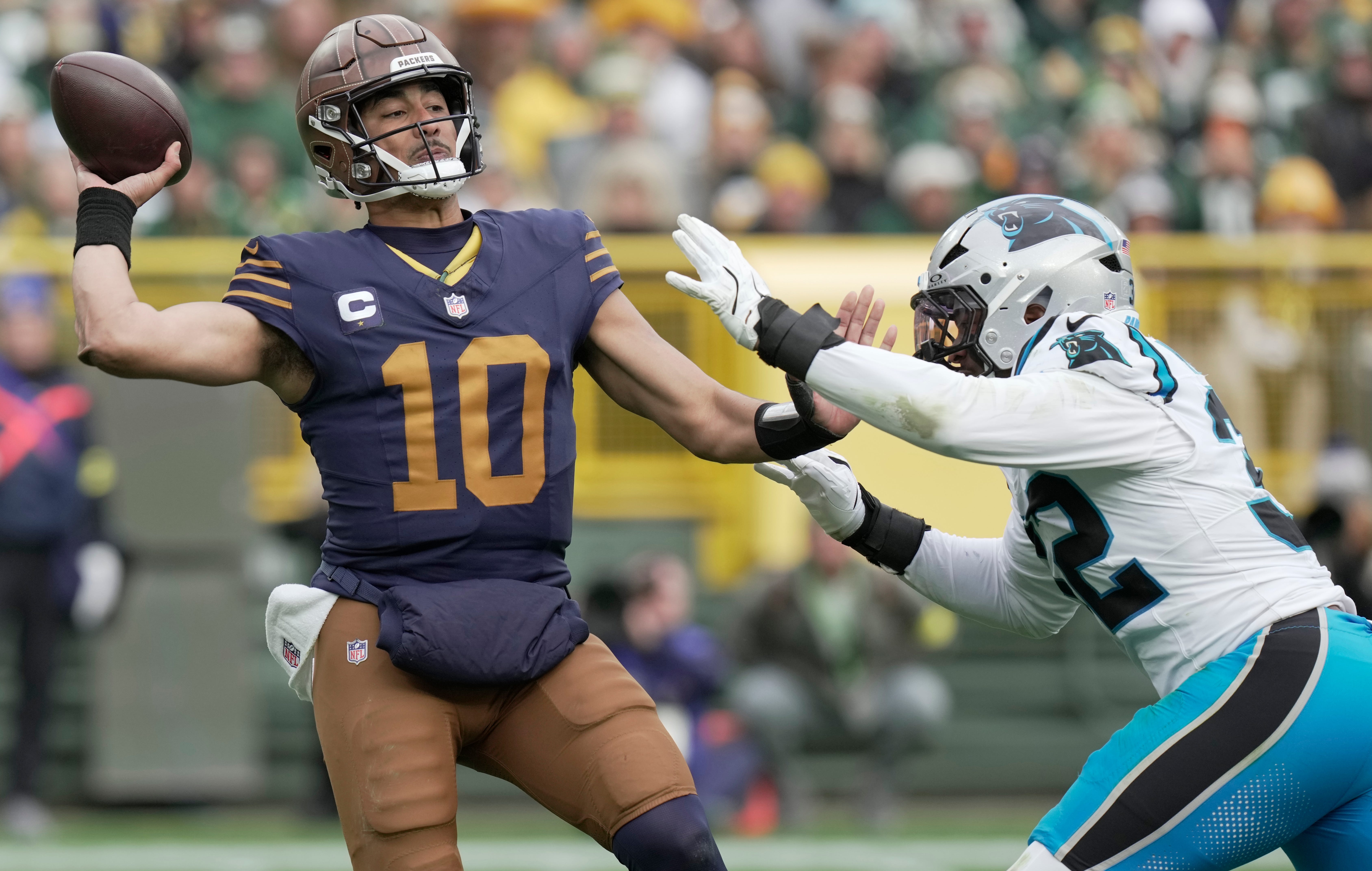 Green Bay Packers quarterback Jordan Love is pressed by Carolina Panthers linebacker Trevin Wallace (32) during the third quarter of their game Sunday, November 2, 2025 at Lambeau Field in Green Bay, Wisconsin.