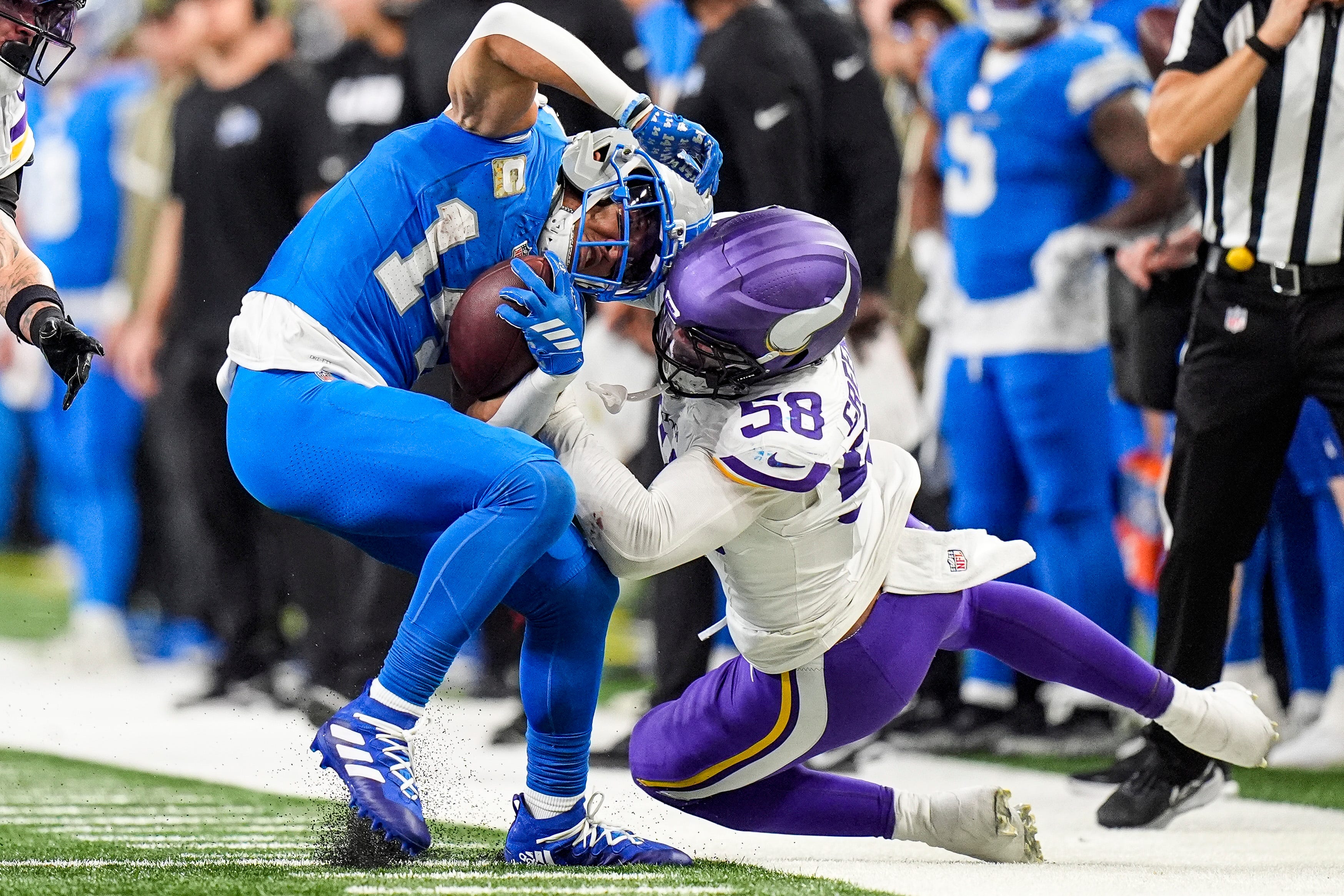 Detroit Lions wide receiver Amon-Ra St. Brown (14) makes a catch against Minnesota Vikings linebacker Jonathan Greenard (58) during the second half at Ford Field in Detroit on Sunday, November 2, 2025.