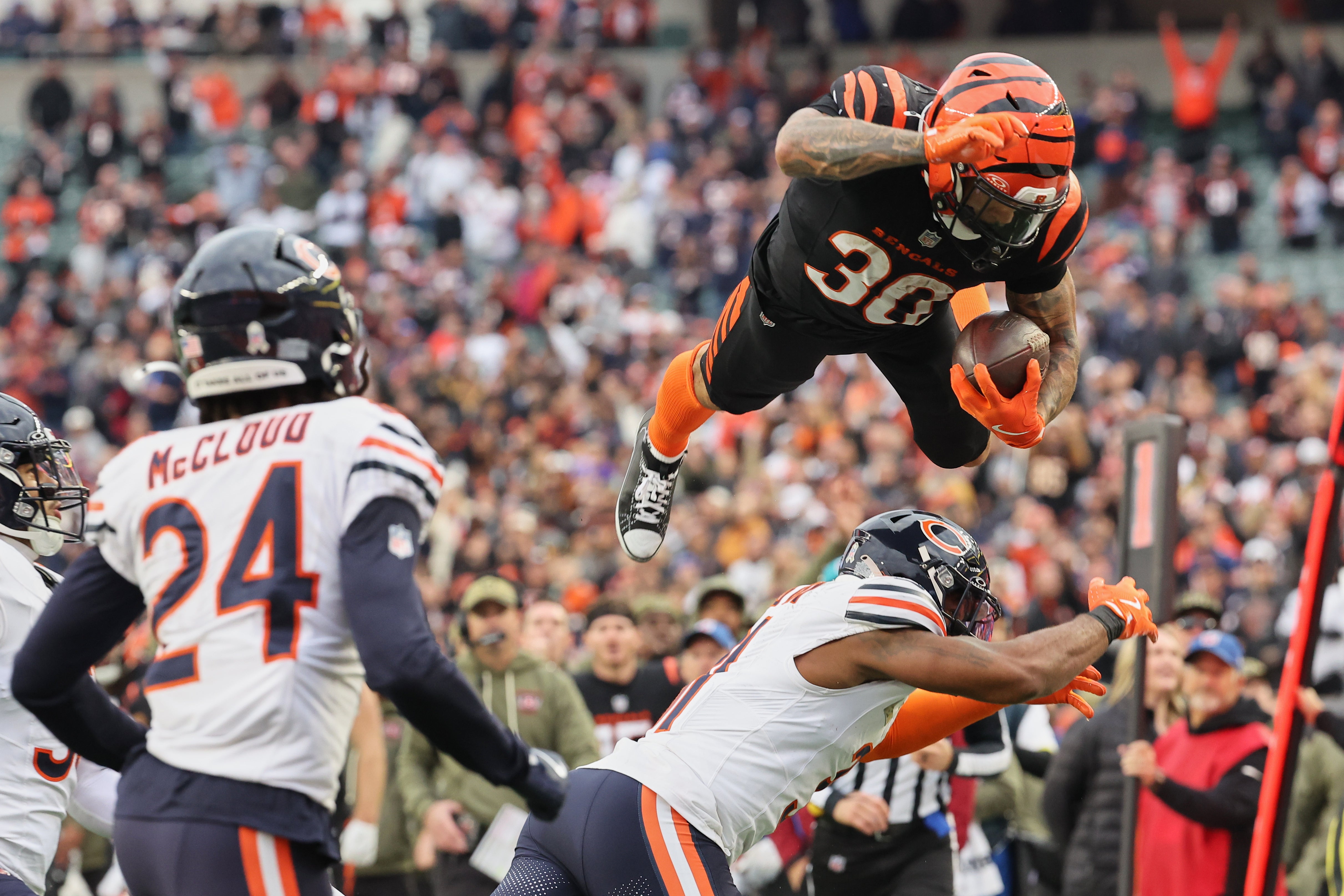 Nov 2, 2025; Cincinnati, Ohio, USA; Cincinnati Bengals running back Chase Brown (30) leaps with the ball over the Chicago Bears defense during the fourth quarter at Paycor Stadium.