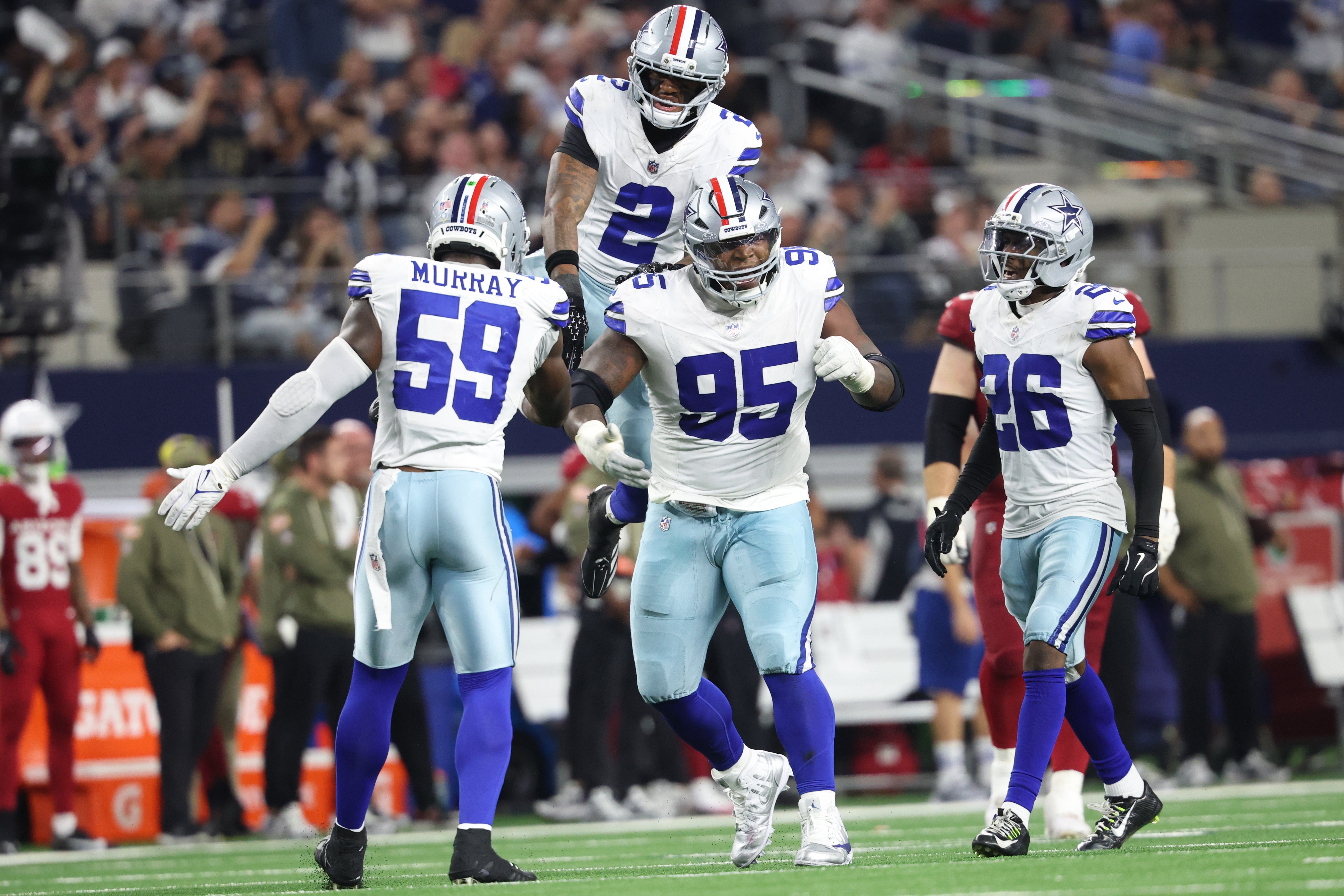Nov 3, 2025; Arlington, Texas, USA; Dallas Cowboys defensive tackle Kenny Clark (95) celebrates with safety Juanyeh Thomas (2) and linebacker Kenneth Murray Jr. (59) and cornerback DaRon Bland (26) in the second half against the Arizona Cardinals at AT&T Stadium.