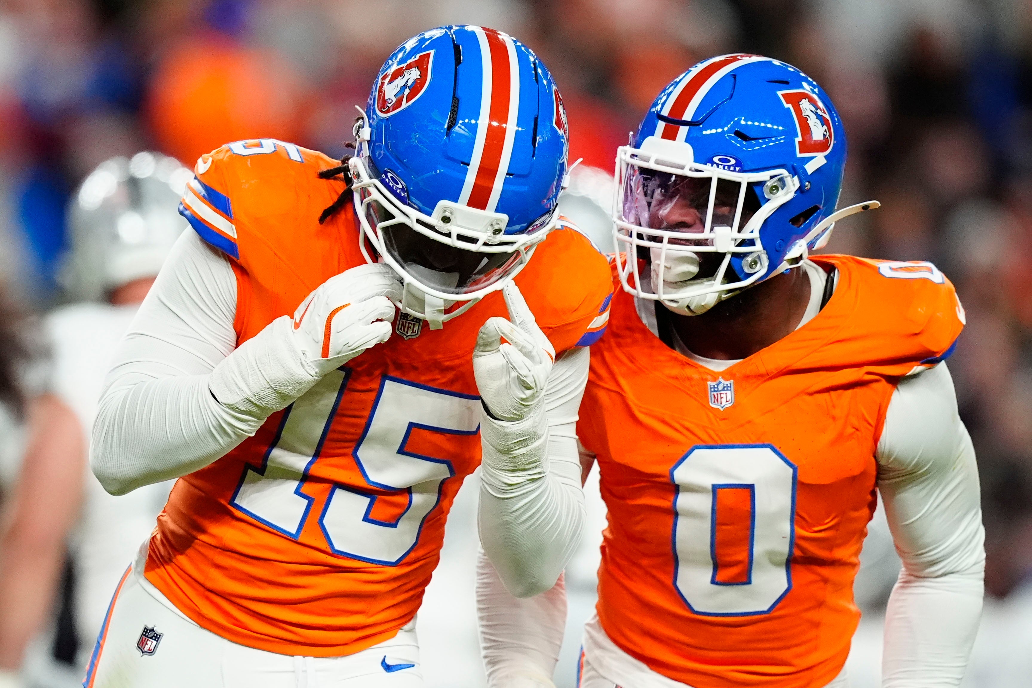 Nov 6, 2025; Denver, Colorado, USA; Denver Broncos linebacker Nik Bonitto (15) and linebacker Jonathon Cooper (0) react during the first half at Empower Field at Mile High.