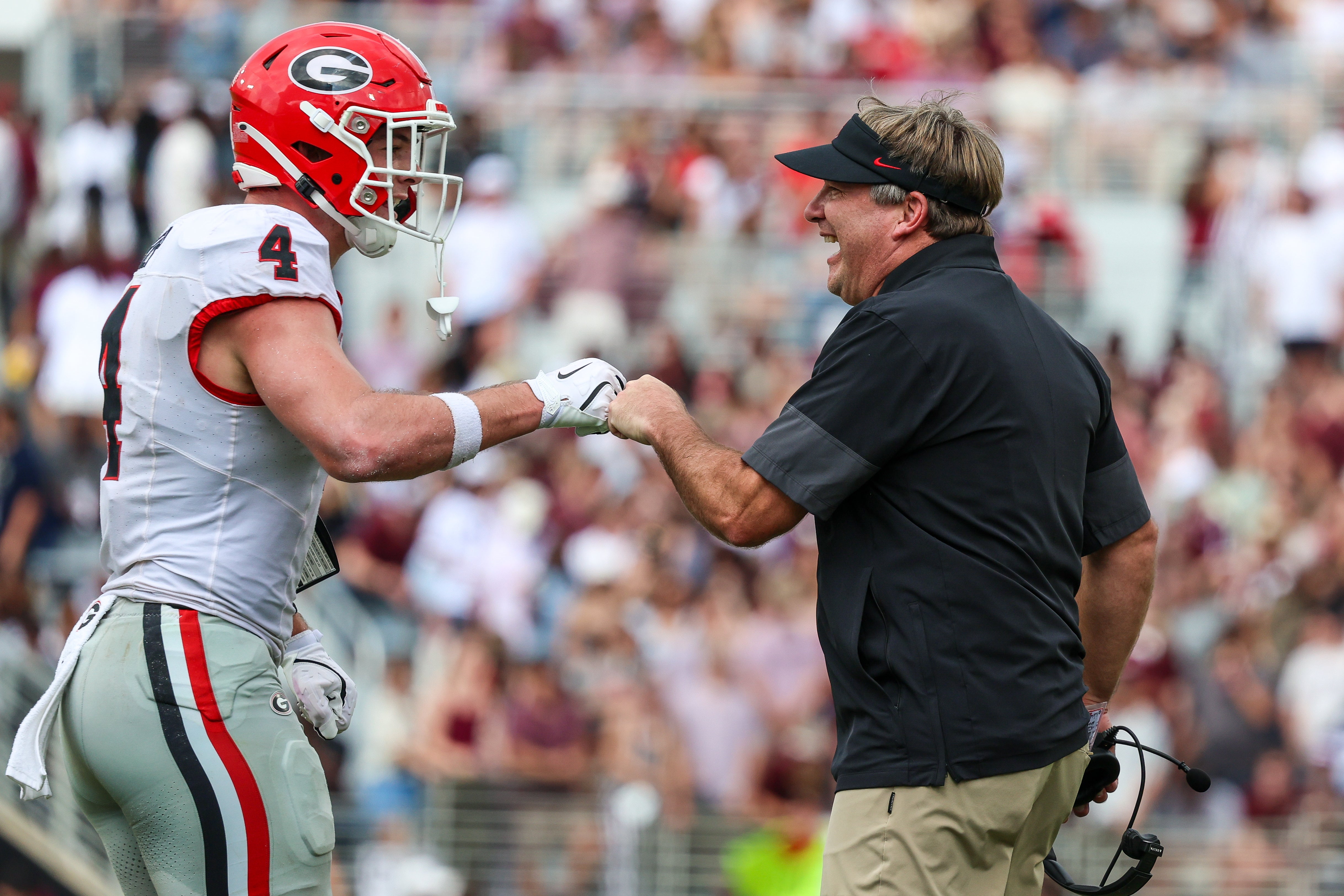 Georgia Bulldogs head coach Kirby Smart and tight end Oscar Delp (4) react after a touchdown against the Mississippi State Bulldogs during the first half at Davis Wade Stadium at Scott Field.