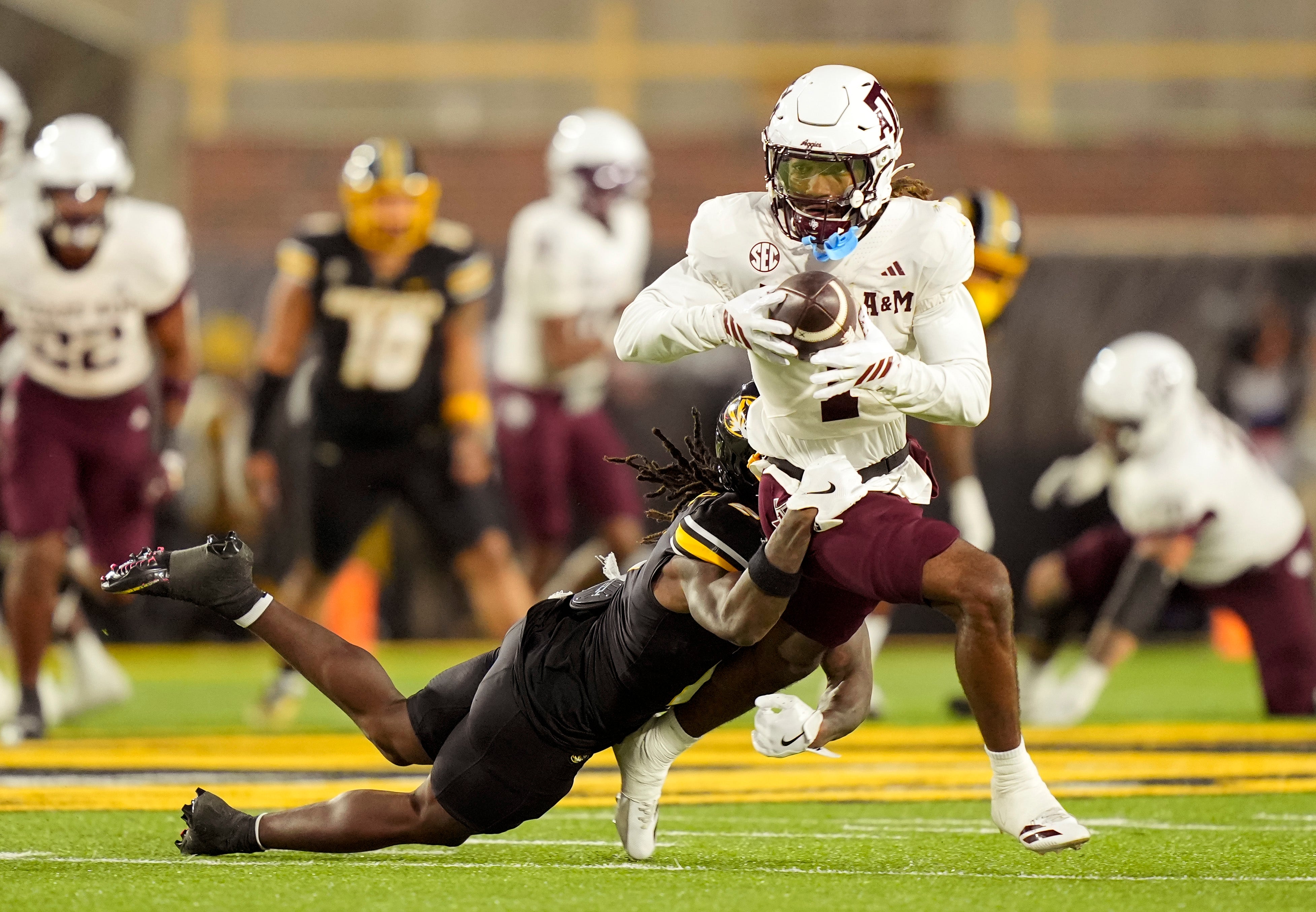 Nov 8, 2025; Columbia, Missouri, USA; Texas A&M Aggies wide receiver Mario Craver (1) runs with the ball against Missouri Tigers cornerback Toriano Pride Jr. (2) during the second half at Faurot Field at Memorial Stadium.