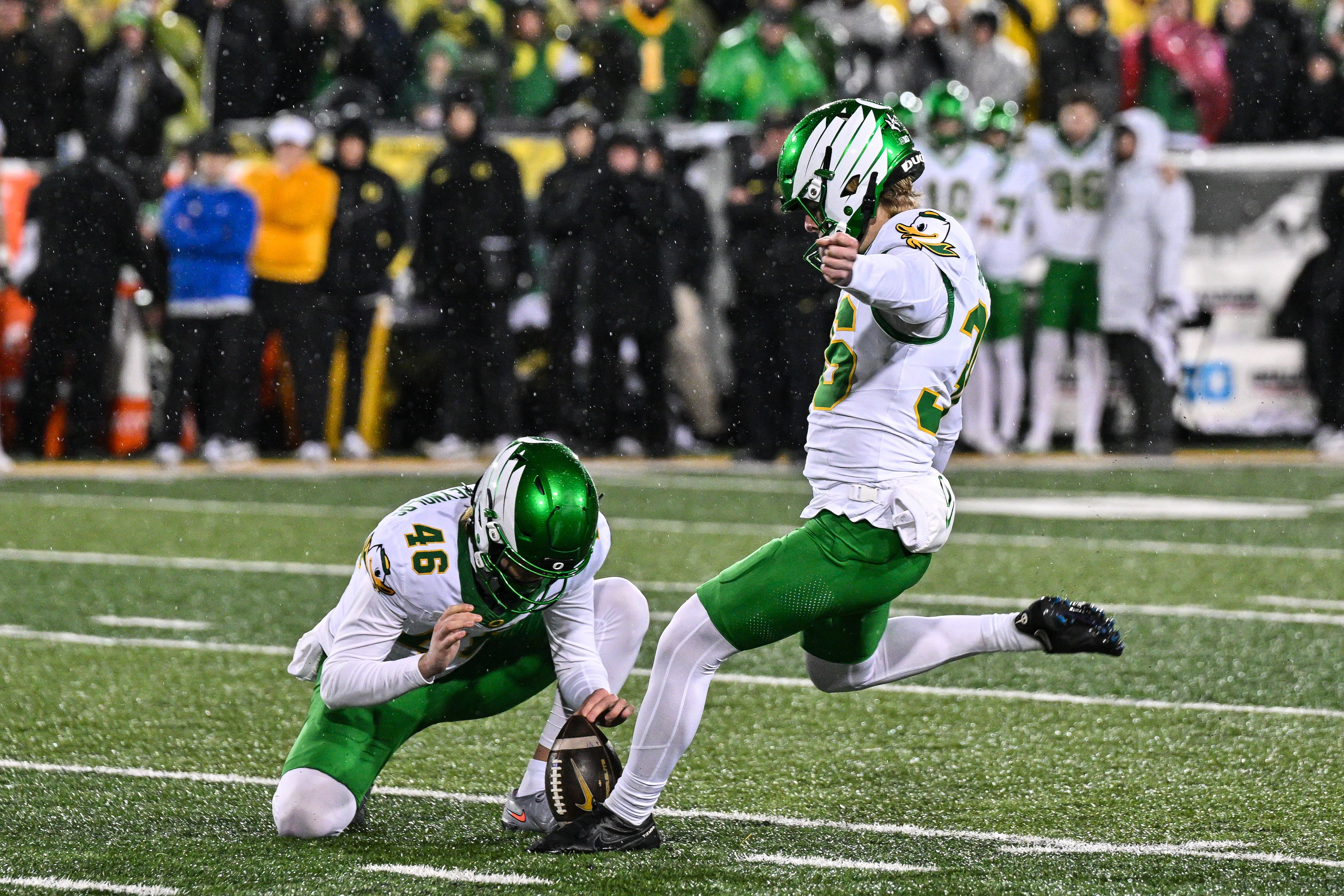 Nov 8, 2025; Iowa City, Iowa, USA; Oregon Ducks kicker Atticus Sappington (36) kicks the game winning field goal as punter James Ferguson-Reynolds (46) holds late during the fourth quarter against the Iowa Hawkeyes at Kinnick Stadium. Mandatory Credit: Jeffrey Becker-Imagn Images