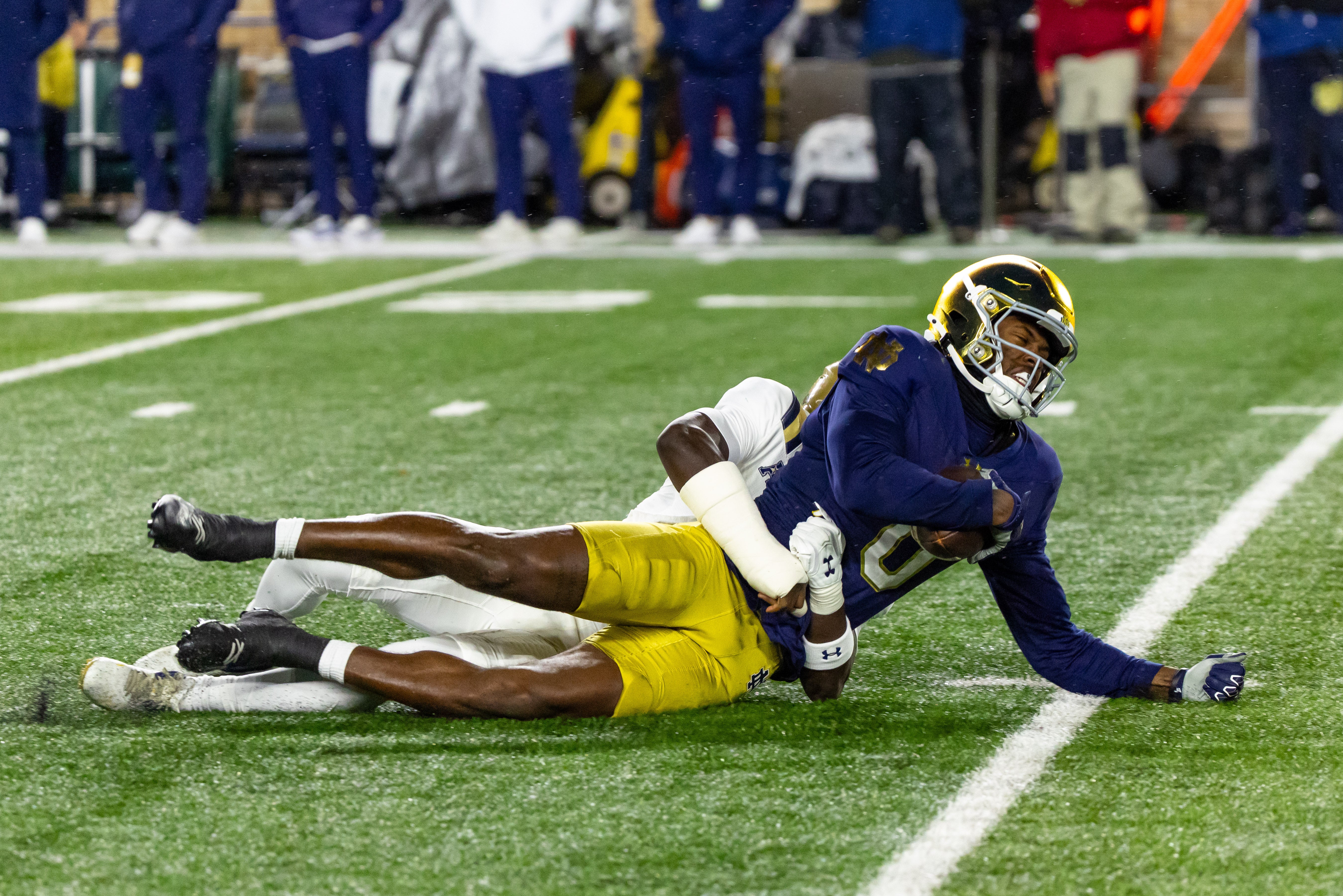 Nov 8, 2025; South Bend, Indiana, USA; Notre Dame Fighting Irish wide receiver Malachi Fields (0) is tackled by Navy Midshipmen cornerback Ira Oniha (3) during the first half at Notre Dame Stadium. Mandatory Credit: Michael Caterina-Imagn Images