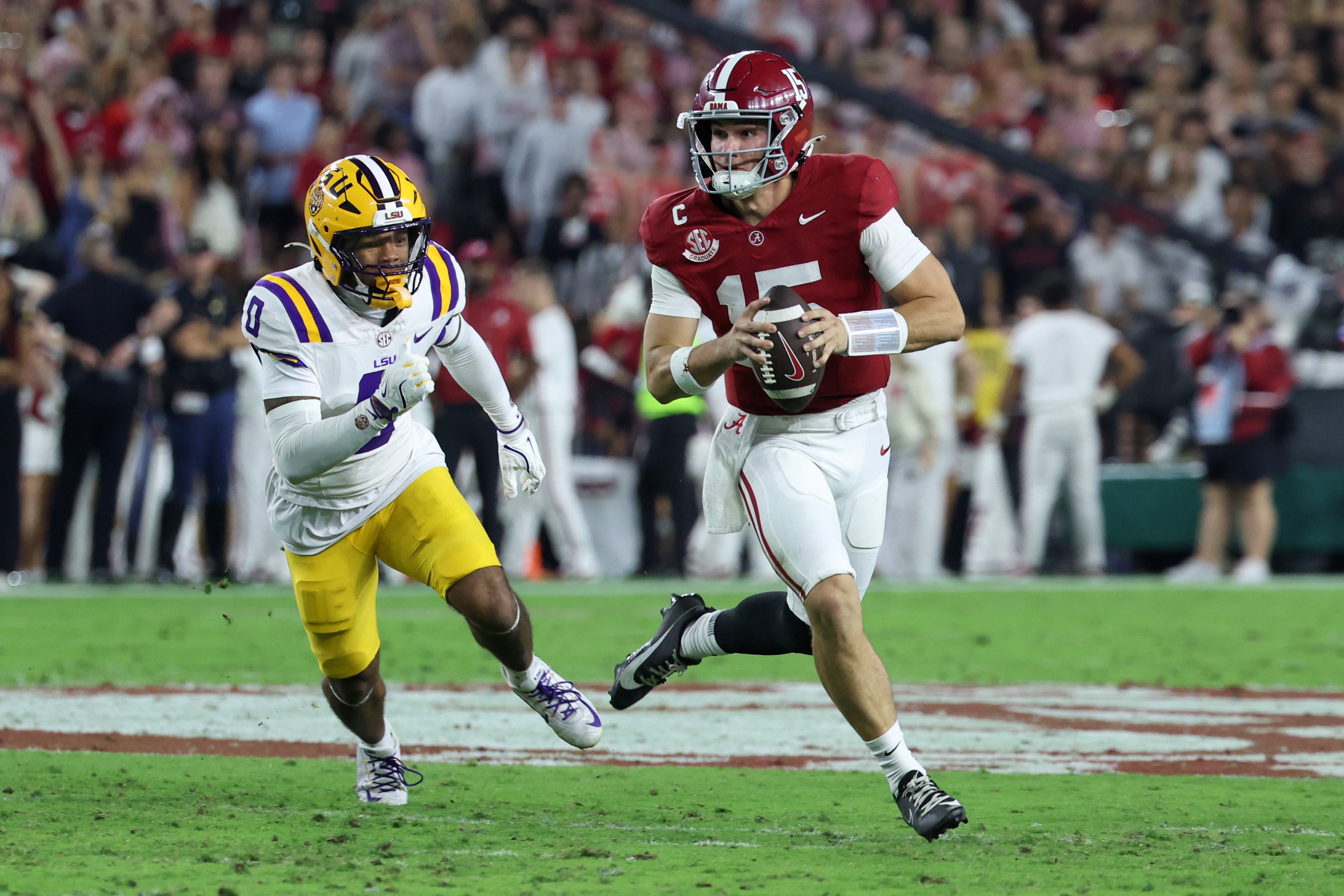 Nov 8, 2025; Tuscaloosa, Alabama, USA; Alabama Crimson Tide quarterback Ty Simpson (15) scrambles with the ball defended by Louisiana State Tigers safety Tamarcus Cooley (0) during the first quarter of the game at Saban Field at Bryant-Denny Stadium.