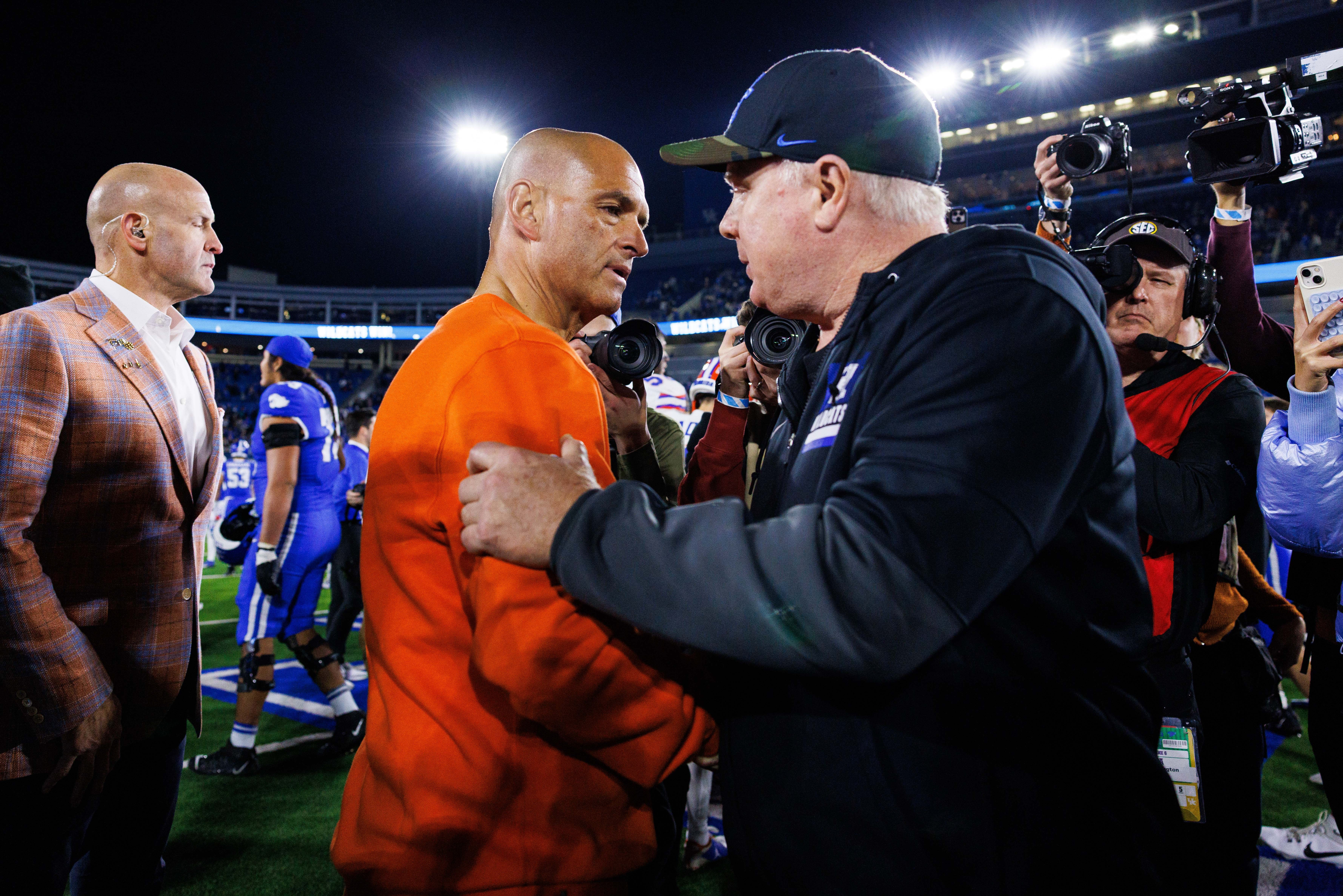 Nov 8, 2025; Lexington, Kentucky, USA; Kentucky Wildcats head coach Mark Stoops and Florida Gators interim head coach Billy Gonzales shake hands after the game at Kroger Field.