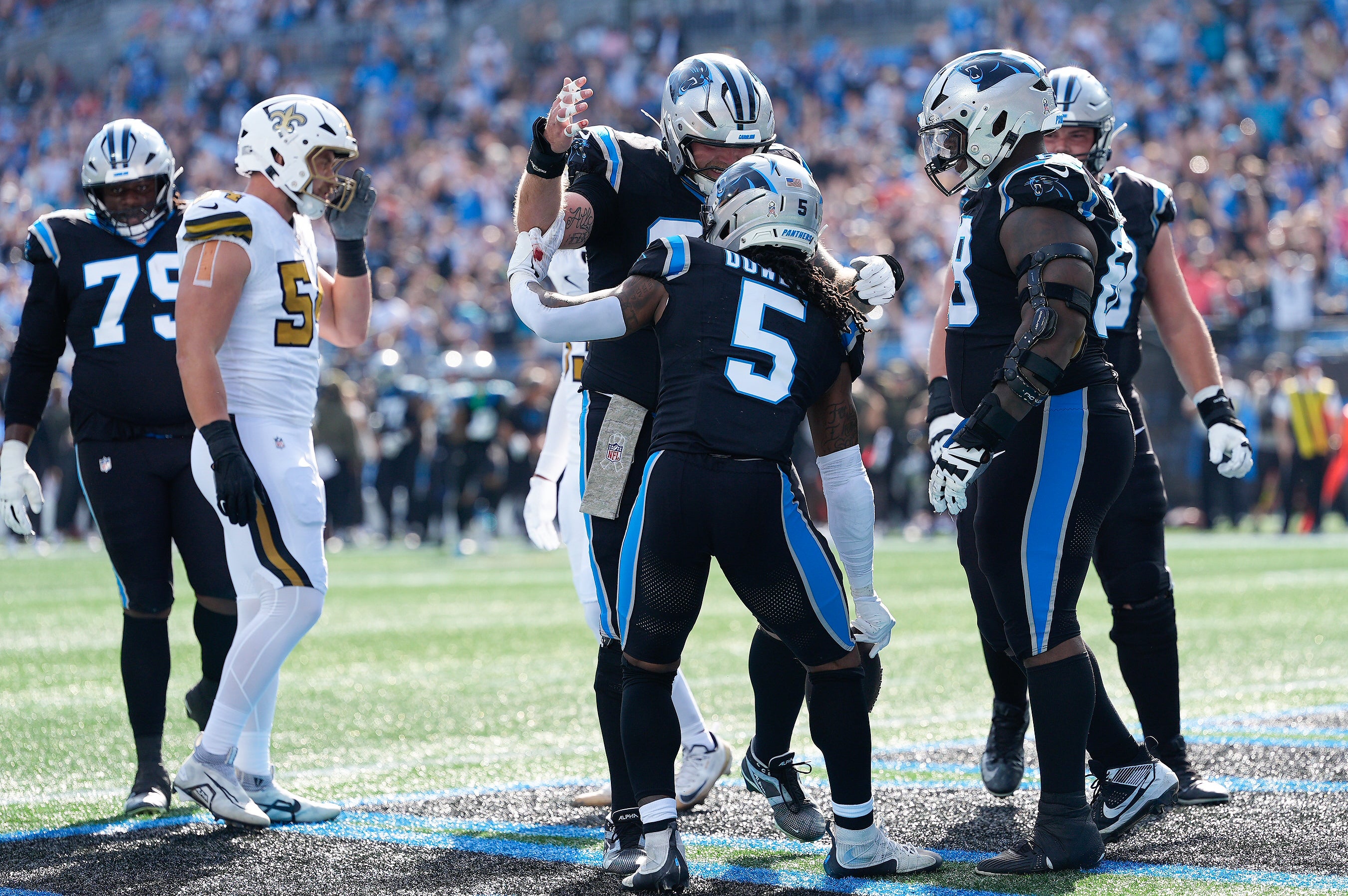 Nov 9, 2025; Charlotte, North Carolina, USA; Carolina Panthers running back Rico Dowdle (5) celebrates with teammates after scoring a touchdown during the first quarter against the New Orleans Saints during the first quarter at Bank of America Stadium.