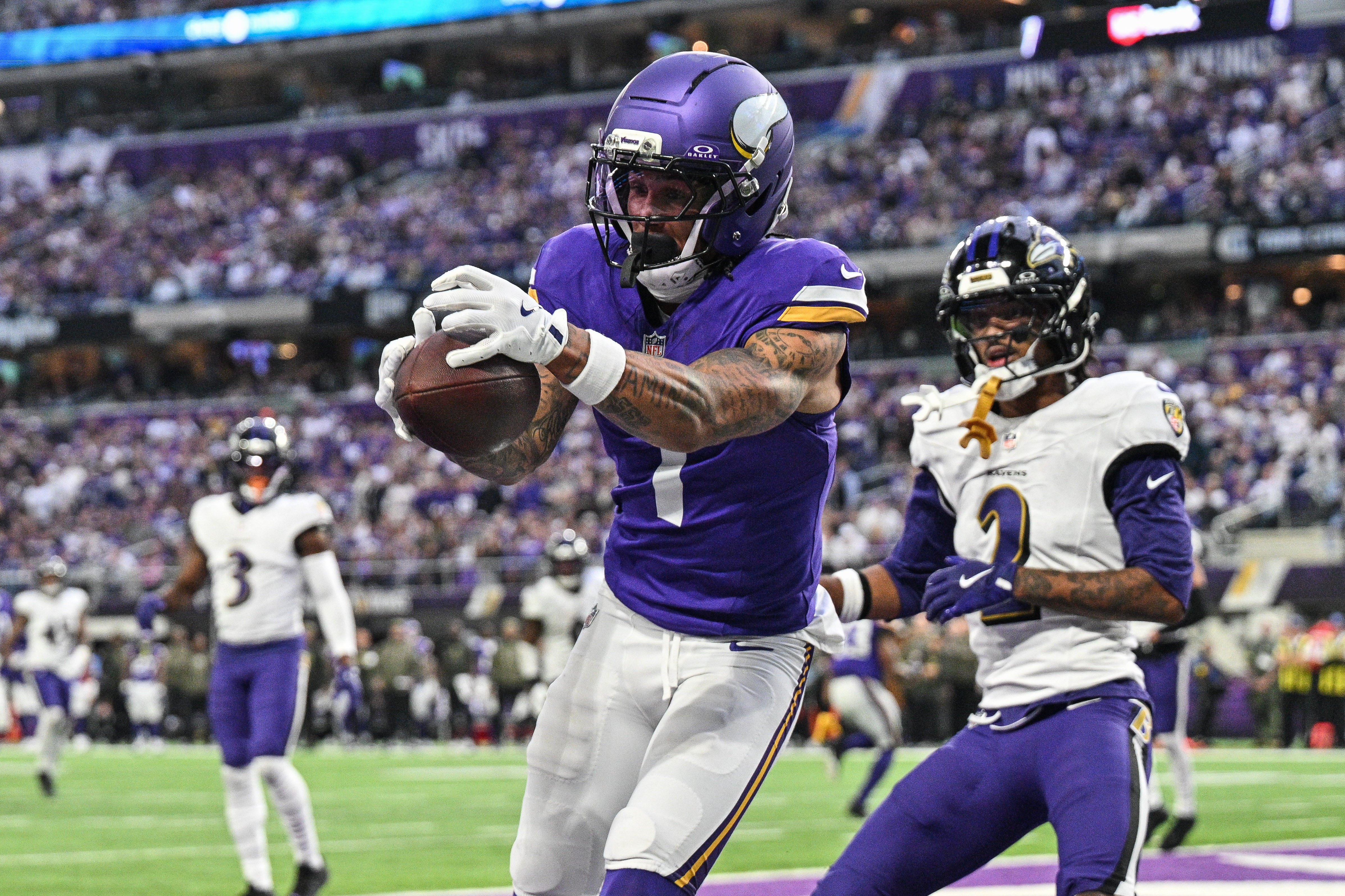 Nov 9, 2025; Minneapolis, Minnesota, USA; Minnesota Vikings wide receiver Jalen Nailor (1) scores on a touchdown pass as Baltimore Ravens cornerback Nate Wiggins (2) defends during the fourth quarter at U.S. Bank Stadium.