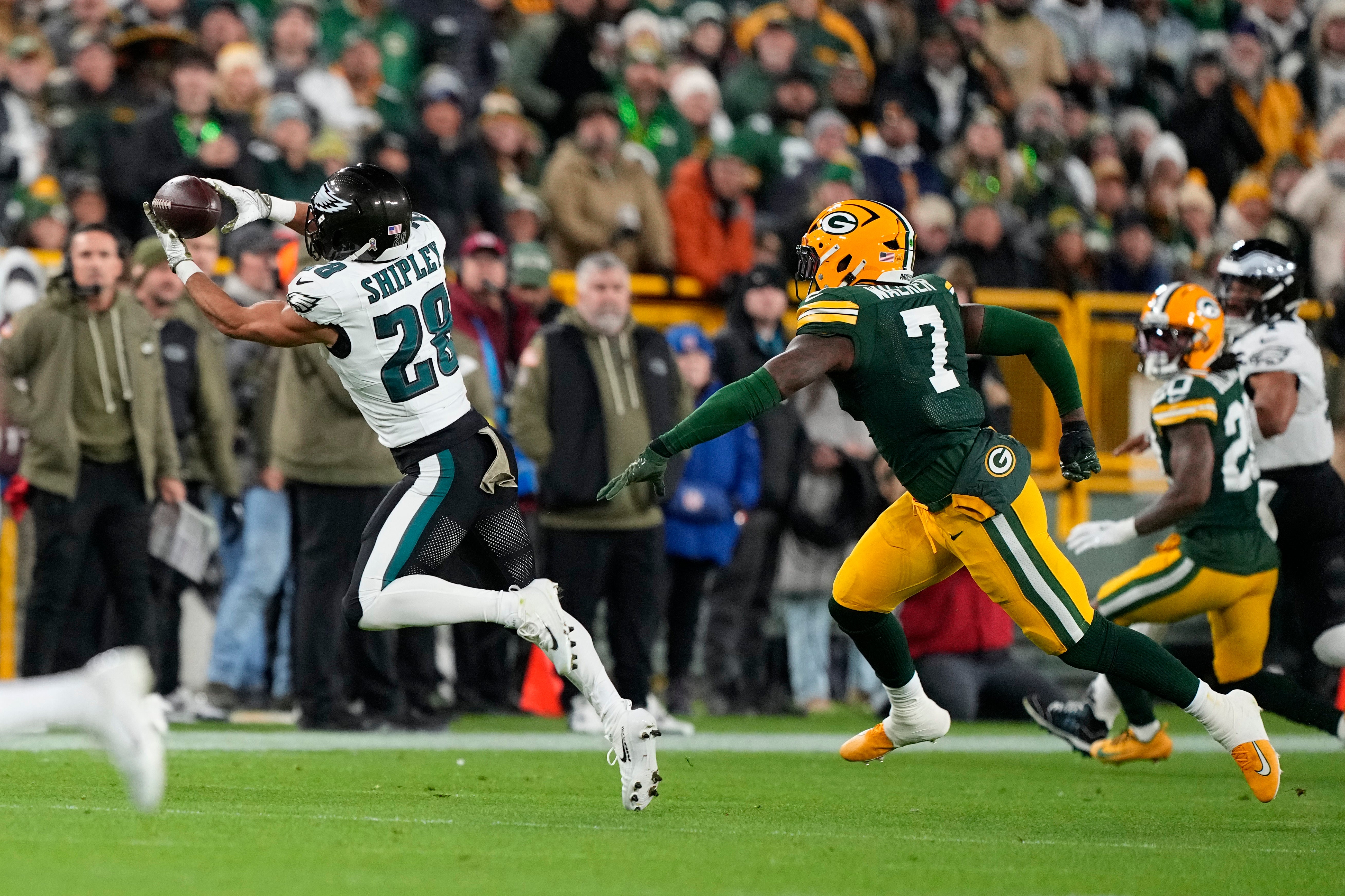 Nov 10, 2025; Green Bay, Wisconsin, USA; Philadelphia Eagles running back Will Shipley (28) makes the catch in front of Green Bay Packers linebacker Quay Walker (7) in the first half at Lambeau Field.