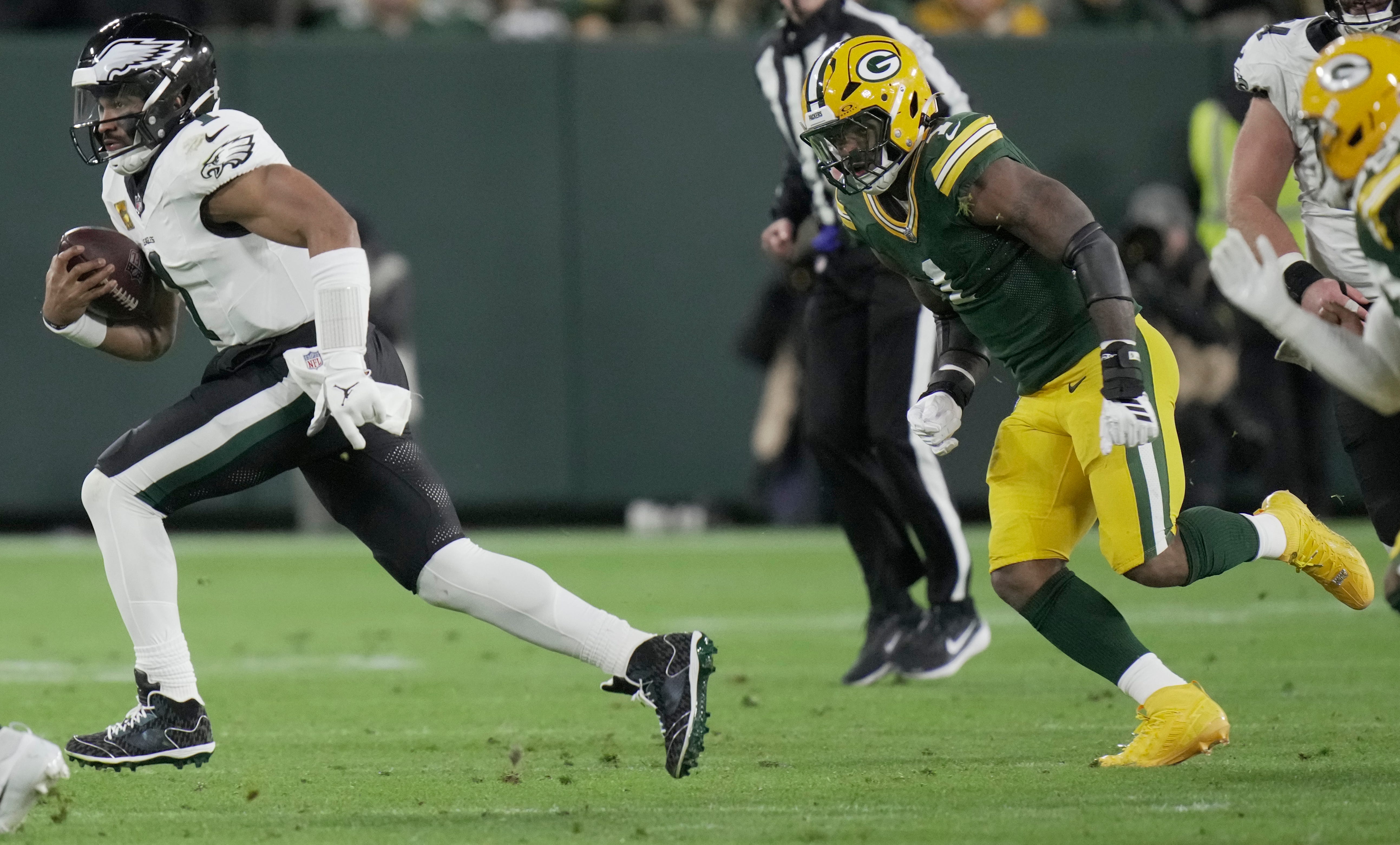 Philadelphia Eagles quarterback Jalen Hurts (1) is pursued by Green Bay Packers defensive end Micah Parsons (1) the second quarter of their game Monday, November 10, 2025 at Lambeau Field in Green Bay, Wisconsin.