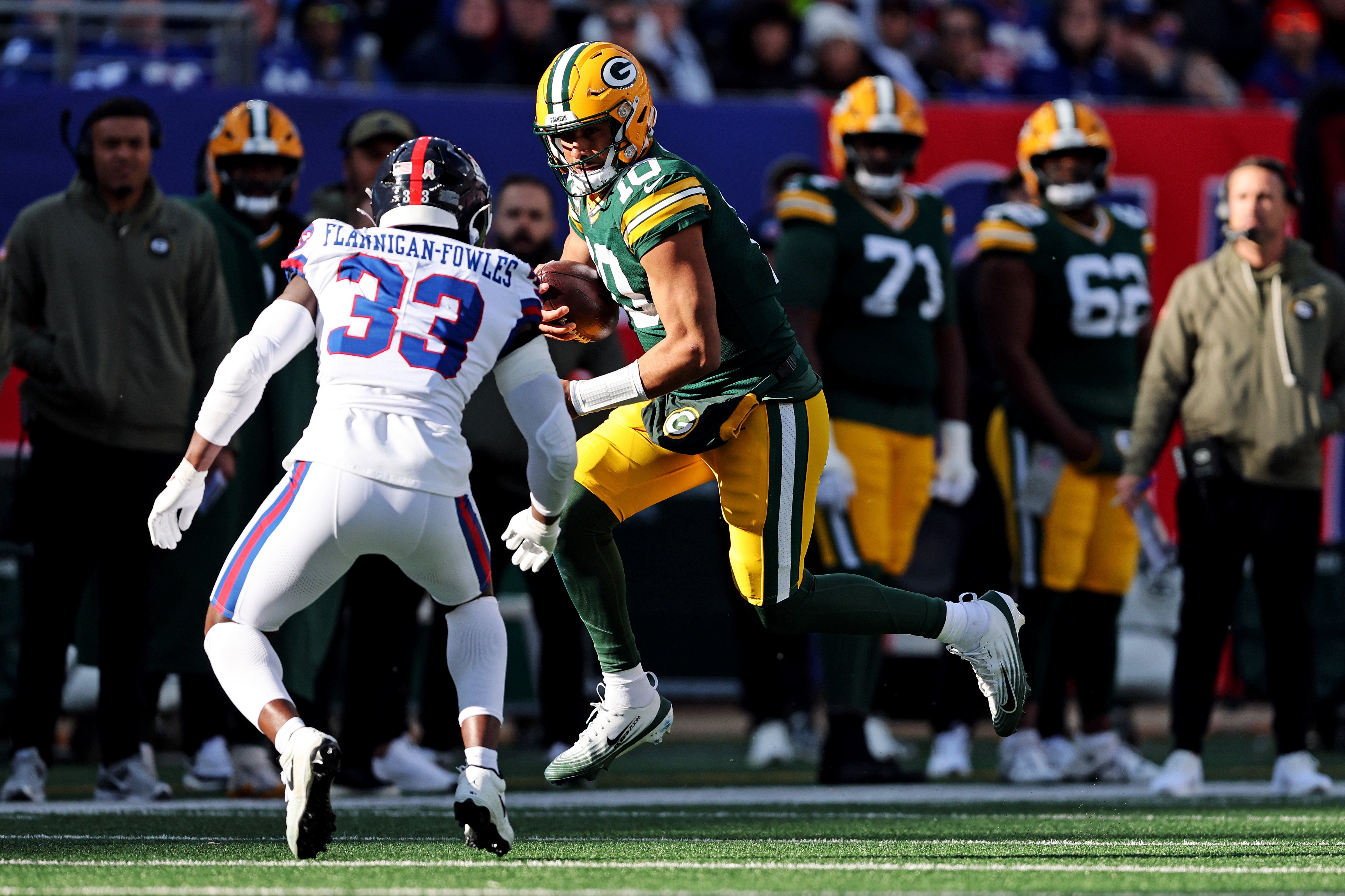 Nov 16, 2025; East Rutherford, New Jersey, USA; Green Bay Packers quarterback Jordan Love (10) runs the ball against New York Giants linebacker Demetrius Flannigan-Fowles (33) during the first quarter at MetLife Stadium.