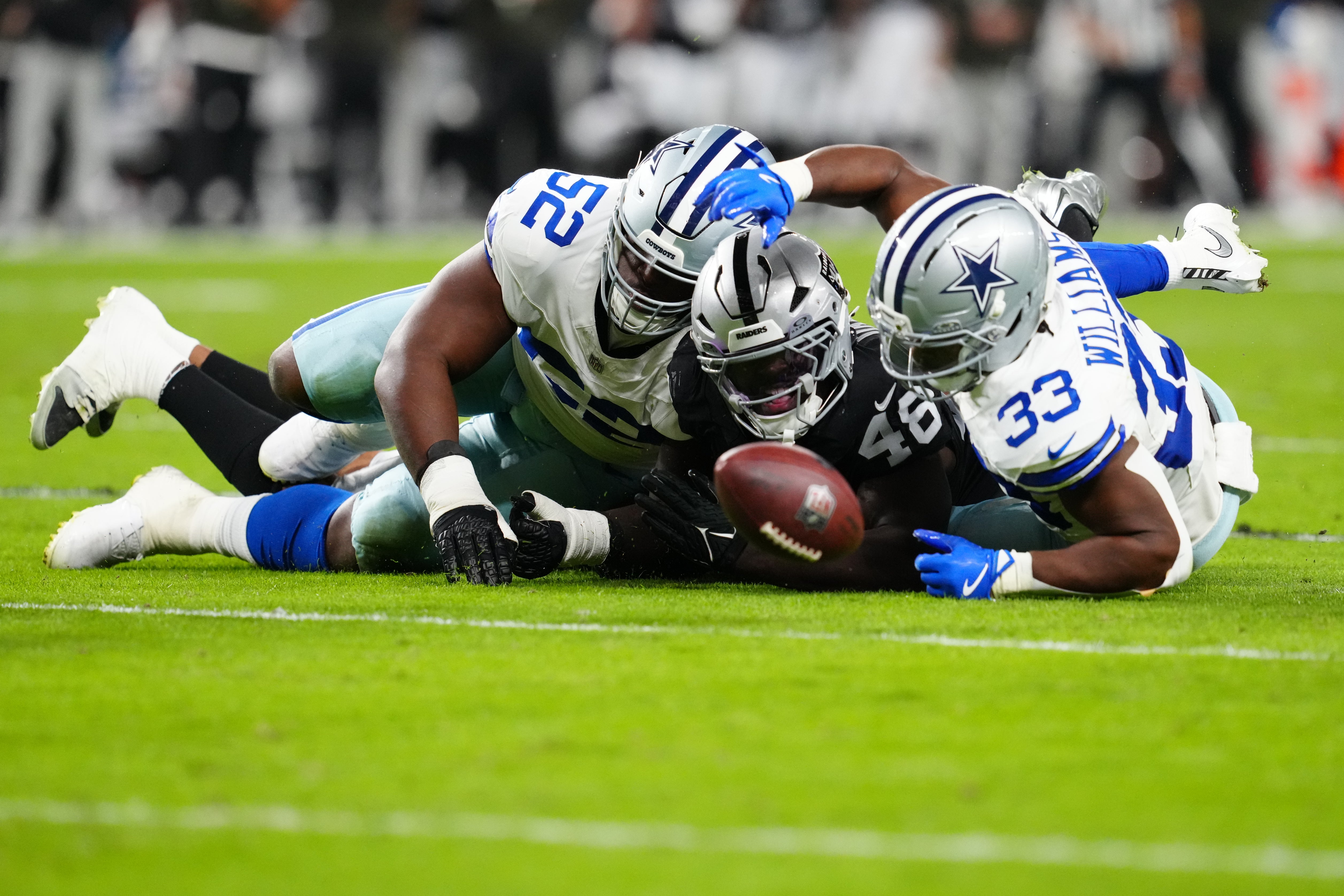Nov 17, 2025; Paradise, Nevada, USA; Las Vegas Raiders linebacker Jamin Davis (48) battles with Dallas Cowboys guard Tyler Booker (52) and running back Javonte Williams (33) for the loose ball during the first half at Allegiant Stadium.